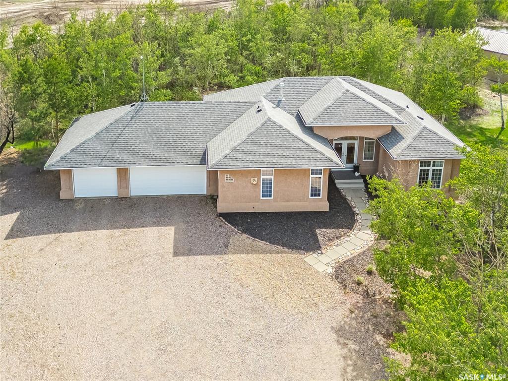 Welcome to 2 Discovery Trail, a beautiful acreage in the hamlet of Discovery Ridge that offers the perfect balance of country living and city convenience. Located just minutes from east side of Saskatoon, this 3.97-acre property features pavement right to the driveway and easy access from Highway 5 and Betker Road.This south-facing bungalow with a walkout basement offers a bright, open-concept layout designed for comfortable family living and entertaining. The main living area seamlessly connects the kitchen, dining, and living room, while large windows throughout the home bring in an abundance of natural light. With 5 bedrooms, and 3 bathrooms across both levels, there is plenty of space for families, guests, or those working from home. Hardwood and ceramic tile flooring add warmth and durability, while the walkout lower level expands the home’s functional living space. Thoughtful interior finishes include stainless steel appliances, a gas range and oven, and two fireplaces that add warmth and character throughout. The home also includes a 3-car attached garage, offering excellent everyday convenience and plenty of room for vehicles and storage.Outside, the mature treed yard creates a private and welcoming setting, complete with two entrances, including one gated, for added convenience and flexibility. A heated shop with a large overhead door adds exceptional functionality, making it ideal for storage, workshop use, or hobbies. Whether you are looking for room to grow, entertain, or simply enjoy acreage living, this property offers exceptional potential in a sought-after location close to Saskatoon.