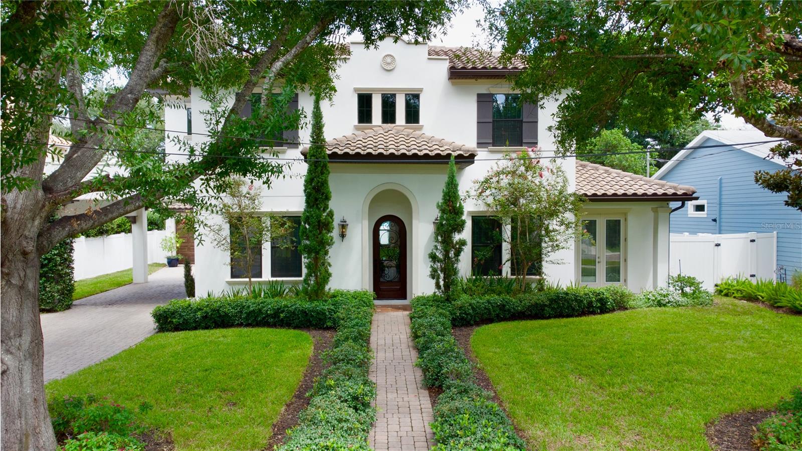 Stunning California Mission-Style Custom Home.  Welcome to a masterpiece of architectural elegance and functional design. This custom 4-bedroom, 4-bathroom luxury home sits on a premium 75x100 foot lot and boasts an impressive 80+ foot paved driveway leading to an elegant porte-cochère and a 2-car freestanding garage. From the moment you arrive, the covered front entry welcomes you with custom Saltillo-style floor tile, flanking wrought iron trellises, and a rich mahogany front door with beautiful wrought iron detailing, hinting at the high-end finishes and thoughtful custom details found throughout this carpet-free sanctuary.  Pass through the grand entryway into a breathtaking 20+ foot soaring foyer, highlighted by a magnificent wrought iron curved staircase. The open living spaces feature luxury engineered wood floors and elegant window molding. Unwind in the family room by the beautiful custom wood and marble-framed gas fireplace, which is perfectly framed by bespoke built-in shelving and lower cabinetry.  Culinary enthusiasts will fall in love with the gourmet custom kitchen. The heart of the space is a massive kitchen island equipped with cabinets on both sides, built-in shelves, and integrated electrical outlets. It is fully outfitted with high-end GE Café Series appliances, featuring a powerful 5-burner gas cooktop and an extra-large matching range hood. Upstairs, a dedicated second-floor utility room offers maximum convenience and comes complete with a premium Maytag washer and dryer.  The home offers absolute privacy with three spacious bedrooms on the 2nd floor, all featuring private en-suite bathrooms. The primary suite oasis is a true retreat, boasting unparalleled storage with two separate walk-in closets—including one so extraordinarily large it offers endless flexibility as a private pet room, nursery, or bonus space. The spa-like primary bathroom features a luxurious clawfoot tub, an expansive walk-in shower, dual sinks, and a private toilet room.  The 4th bedroom is on the first floor with a full bathroom just off the hallway.  This 4th bedroom could also be used as a den or office.  Step outside to find beautiful, professional landscaping throughout, including freshly laid new sod in the backyard. It is perfect for outdoor living and features a large, covered, screened, and paved lanai that offers a peaceful retreat.  Built with ultimate peace of mind, this home features hurricane-resistant construction across all windows and structures. Modern mechanicals include a highly efficient tankless gas water heater and perfect climate control via two separate air conditioning units. Integrated security cameras monitor the front door, porte-cochère, and private lanai for maximum security. Do not miss your chance to own this one-of-a-kind custom home!