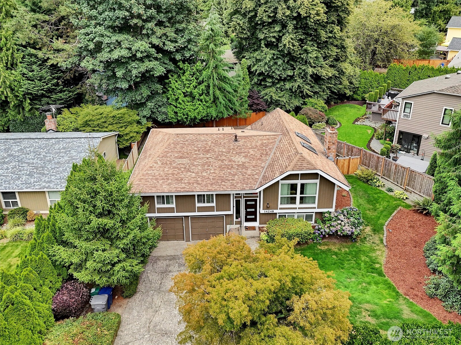 Move right in to this stylish NW Contemporary split w/Dutch gable roof, near shopping & restaurants! 2 suites, one on each floor! Sophisticated upgrades, new oversized Trex entertainment deck. Recently painted interiors. Tile entry, cathedral ceiling in open living room, skylights, & formal dining room, heat pump-A/C. Lodge like engineered hardwood floors. Interior painted 2025, newer front door, upgraded lighting, closet organizers. Beautiful eat-in kitchen has all the bells and whistles, dark cherry tone soft close cabinets, slab granite counters, glass tile splash, gas range, stainless appliances. Dining room & deck overlook park-like fenced yard! Primary suite w/dual closets. A masonry fireplace on each floor. 3 showers! Big garage for workshop. New furnace & water heater. Large, corner lot.