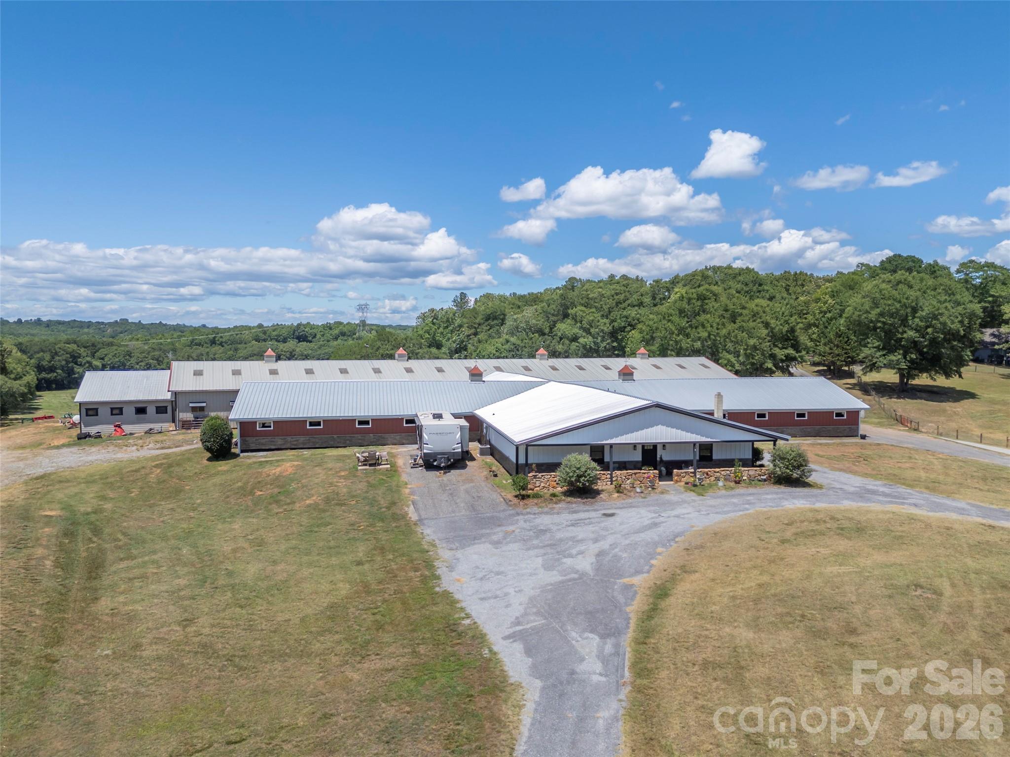 Set along the Broad River, this 64.59-acre equestrian property offers an exceptional opportunity to own a well-established horse farm with the acreage and infrastructure to support a professional operation or private equestrian estate. Rolling pastures, productive hay fields, and extensive river frontage create a beautiful and highly functional setting in the foothills of North Carolina. At the heart of the property is an impressive 29-stall barn designed for serious equestrian use. Thoughtfully updated and exceptionally maintained, the facility features both indoor and outdoor riding arenas, multiple tack rooms, a heated and cooled wash room, comfortable viewing room, round pen, trailer storage, and additional infrastructure to support training, boarding, breeding, or a private horse operation. Two Big Ass Fans in the indoor arena provide added comfort and airflow throughout the warmer months. A private two-bedroom apartment within the barn provides convenient on-site accommodations for a trainer, farm manager, staff, or owner. The surrounding acreage includes established pastures and productive hay fields, offering the ability to produce hay directly on the property while maintaining ample space for horses and continued agricultural use. With Broad River frontage adding both natural beauty and recreational opportunities, the property offers a combination of usable acreage, established equestrian improvements, and privacy that can be difficult to replicate. Located less than 25 minutes from Tryon International Equestrian Center and within convenient reach of Asheville, Charlotte, and Greenville-Spartanburg airports, the farm is well positioned for both regional and national equestrian connections. An additional approximately 14.86-acre parcel may also be available for purchase, offering buyers the opportunity to expand the farm and add acreage with potential for a future residence. Whether envisioned as a professional training and boarding facility, breeding farm, or private equestrian retreat, this 64.59-acre property offers the foundation for a truly exceptional horse operation in Western North Carolina. NO DRIVE BYS! PLEASE DO NOT DRIVE DOWN JOANDA FARM ROAD. Call for an appointment.