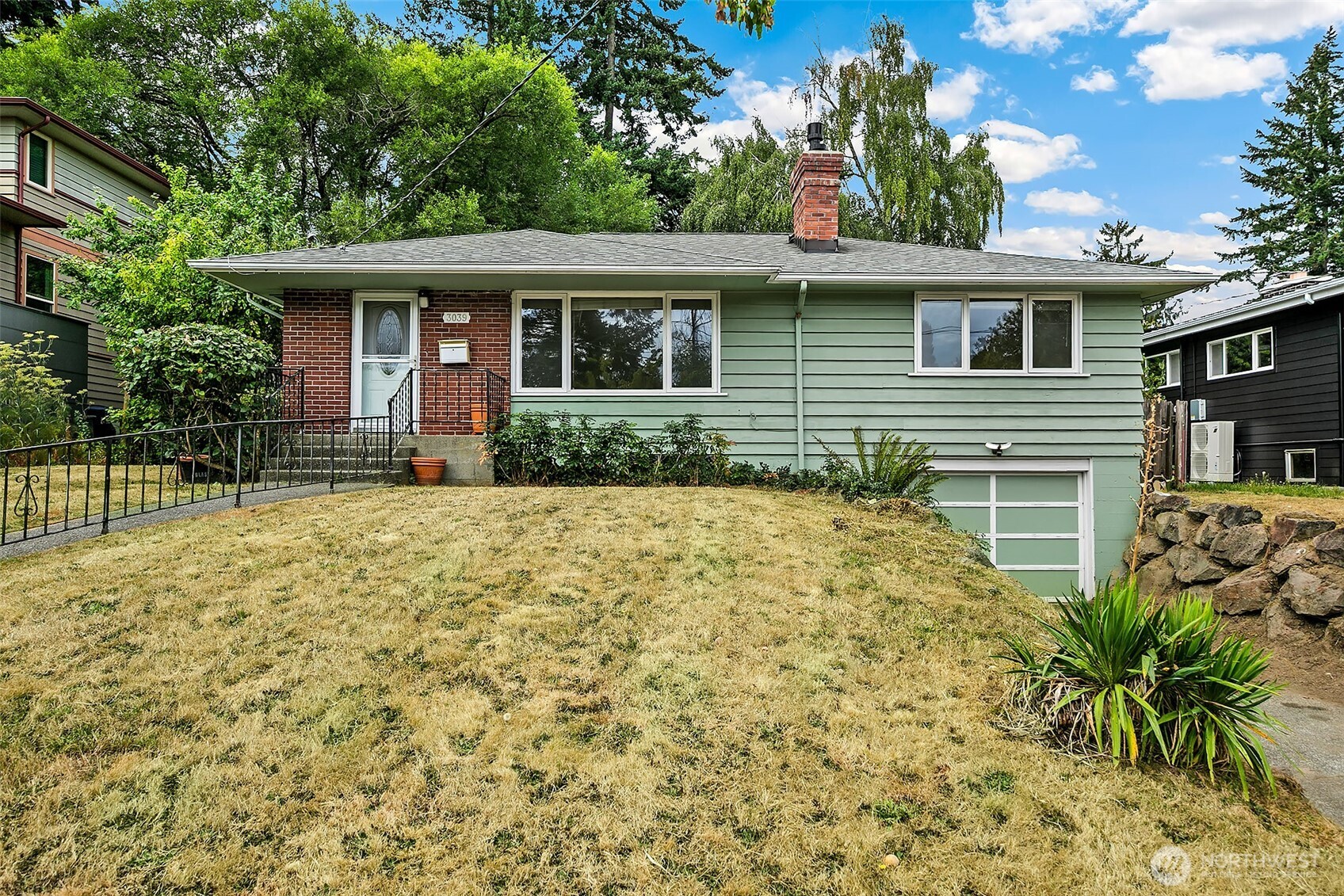 Charming Mid-Century gem located in the popular Admiral neighborhood of West Seattle! This 4-bed, 1.5-bath home spans an expansive 2,230 sq ft. Revel in the sun-drenched, east-facing living room with a cozy gas fireplace. The main level graces you w/ 3 bedrooms, a full bath, & elegant, refinished hardwoods. The spacious kitchen showcases stone counters, updated cabinetry with some glass front cabinets, and a garden window! Adjacent to the kitchen is a family room with charming built-in benches and French doors that open to the private fenced backyard. The lower level offers versatile a family room with another gas fireplace, 4th bedroom, ½ bath and large utility room. One car attached garage with a work bench and storage. The backyard is a gardener’s delight, complete with fruit trees and a west facing composite deck, perfect for your BBQs! Lots of updates including new carpet downstairs and fresh paint throughout the interior. Close to the shops and restaurants of the Admiral Junction! Take a stroll along California Avenue SW, and experience local shops and markets, and frequent community events. Alki Beach is just minutes down the hill! All of this plus an easy commute to Downtown Seattle!