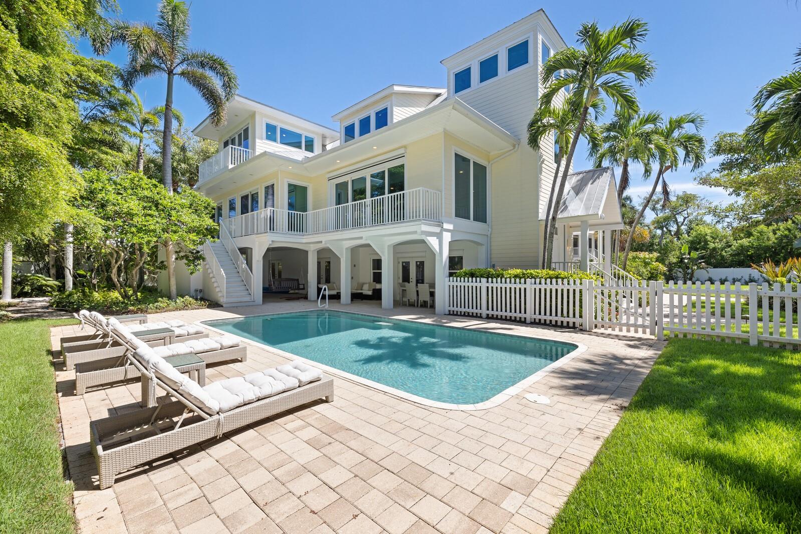 Incredible Value!  Set on more than half an acre along a quiet private street, 2021 20th Street W is the kind of property Boca Grande families hold onto for generations. Two separate residences give everyone room: a spacious five-bedroom main home and a charming three-bedroom guest cottage, totaling eight bedrooms, seven baths, and 5,792 square feet.The main home is bright and open, with soaring ceilings, oversized windows, and natural light throughout. A European-designed kitchen anchors the living spaces and opens to a beautiful private pool and patio, where long lunches, sunset cocktails, and family dinners happen naturally. The fully fenced yard, framed by mature tropical landscaping, offers true privacy and a safe, generous space for children and pets to play.  Deeded beach access puts the Gulf moments away, and the Village is an easy bike ride down the path, with its shops, restaurants, and community center close by. Secluded yet central, this is island living exactly as it should be: private, relaxed, and made for making Boca Grande memories!