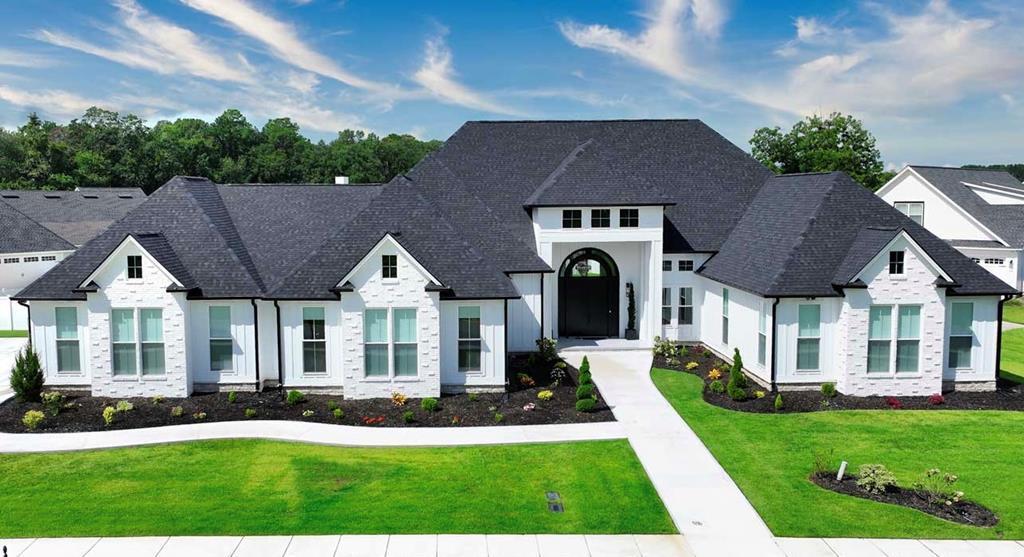 Welcome to 347 Madison Grove Blvd., a home where everyday life feels like a luxury retreat. From the moment you step through the grand double doors into the soaring foyer, you'll know this is more than a house — it's a lifestyle.  Imagine mornings by the double-sided fireplace, coffee in hand as sunlight pours into the den, or slipping into the home office for a quiet, productive day. In the evenings, the chef's kitchen becomes the heart of the home — double islands, quartz counters, and commercial-grade appliances make everything from weeknight dinners to holiday gatherings effortless.  When it's time to unwind, the theater room with its own full kitchen and ice maker sets the stage for family movie nights, lively game days, or casual evenings with friends. And when guests come to stay, they'll each have their own private retreat — every bedroom has its own bathroom and walk-in closet.  The primary suite is a world of its own: custom his-and-her closets, dual toilets, a spa-inspired shower, and a soaking tub that makes every day feel like a trip to the spa. Even the details make life easier — a three-car garage with finished touches, double laundry hookups, a drop zone for daily essentials, and bonus storage above the garage.  Step outside, and the lifestyle continues. The covered back porch is perfect for morning coffee, weekend cookouts, or unwinding at the end of the day. And with plenty of space to add a swimming pool, the backyard is ready to become your own private resort.  All of this is tucked inside Madison Grove,  one of Thomasville's most beautiful neighborhoods — where kids ride bikes down tree-lined sidewalks, neighbors wave hello, and families gather at the clubhouse or pool.  If you've dreamed of a home that blends elegance with ease, where every detail has been thoughtfully designed, and where life feels both indulgent and inviting, 347 Madison Grove Blvd. is waiting for you.