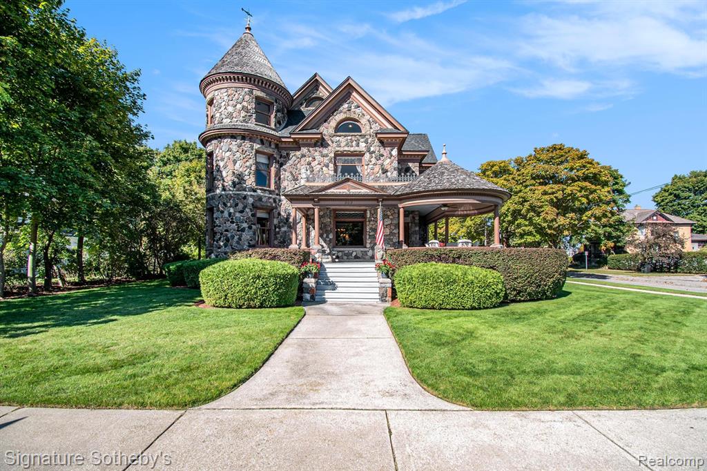 THE CASTLE, like no other!   Fully furnished. This property is being sold Turnkey w/hand carved solid wood furniture, artwork, area rugs, & lamps included in sale. Extraordinary with unsurpassed artistry, prime location within the City of Alpena, Michigan w/gorgeous Lake Huron views. The Castle embodies timeless architecture w/the preservation design for present day lifestyles. Enjoy a piece of history w/this restored stunning Victorian stone home, featuring ornate woodwork, leaded glass windows, & wraparound porch. The home originally built for Charles Henry, a Michigan State Senator in 1902. The original design was based on architect H.H. Richardson’s Victorian Romanesque style. The interior design was done by Marshall Fields of Chicago, Il ,who hired an artist from New York to paint oil on canvas murals on all the dining room walls.  Convenient to this location is the municipal owned waterfront boat harbor across the street featuring rental boat slips, as well as tennis courts, park, band shell, & public beach. Alpena is also home to the Thunder Bay National Marine Sanctuary & Underwater Preserve consisting of 4,300 square miles. Note the exquisite hardwood flooring thru out & leaded glass accent windows.  Hand carved stairwell & cornices show the craftsmanship of that period. There are 3 unique fireplaces; in the foyer sitting room, library, &  dining rm. The open flow of the great room offers a window turret area, original Waterford crystal chandelier & large entertaining space.  The library with stunning carved partner desk. The dining room is off the foyer w/a beautiful hand painted oil on canvas wall mural. The kitchen is designed for contemporary living with newer cabinetry and stainless appliances. There is a breakfast area in the kitchen overlooking the elevated patio for casual outdoor dining & renovated 1st  floor powder rm. Second level offers 5 bedrooms which include staged bedding.  Third level is a bonus room w/plenty of extra space.  BATVAI