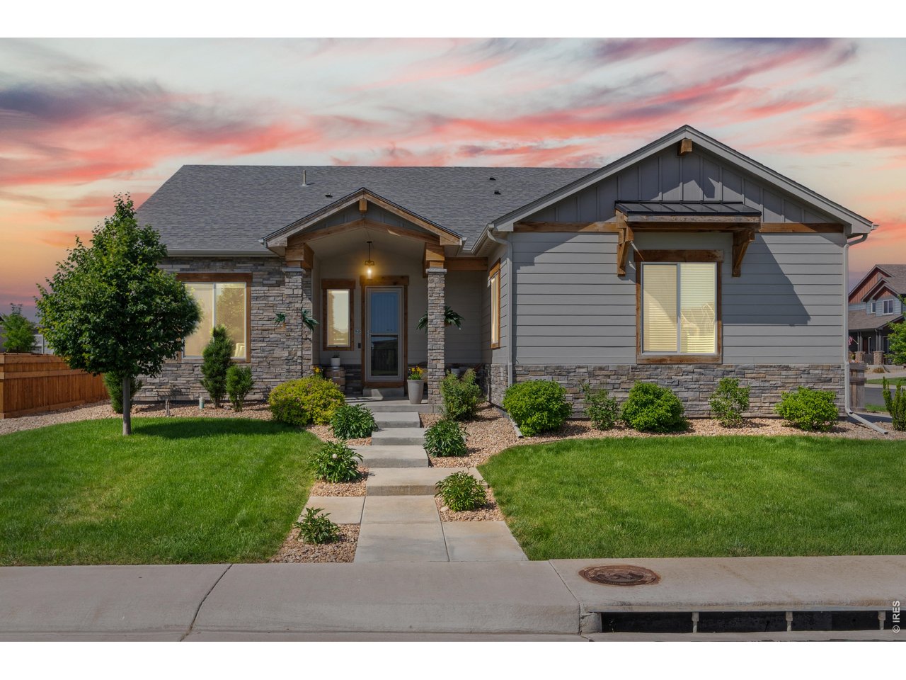 More than a home, this is a lifestyle. Located in Windsor's highly sought-after Greenspire neighborhood, this beautifully upgraded 5-bedroom, 3-bath ranch-style home sits directly across from open space and playground plus it is just a short walk to Windsor Lake, trails, parks, boating, fishing, swimming, summer concerts, and community events. The home is designed for easy living, offering true main-level living with a luxurious primary suite, two additional bedrooms, a full bath, and main-floor laundry. The spacious living room features vaulted ceilings, a gas fireplace, recessed lighting, ceiling fan, and large south-facing windows that fill the home with natural light. The gourmet kitchen is built for entertaining with a large island, ceiling-height white cabinetry, pantry, secondary prep sink with water filtration, and an open flow into the dining and living areas. Step outside to a low-maintenance backyard designed for relaxation and entertaining. Enjoy a huge concrete patio with multiple gathering spaces, including a covered dining area and two additional seating zones shaded by retractable awnings with integrated lighting and automatic wind sensors. Artificial turf provides a green, usable yard without the maintenance of mowing. The main-level primary suite is a true retreat with vaulted ceilings, large windows, remote-controlled privacy blinds, and a stunning five-piece bath featuring a soaking tub, glass shower, dual sinks, and walk-in closet. The finished basement expands your living space with a large recreation room, two additional bedrooms, a stylish 3/4 bath, and a generous unfinished storage area. Situated on a corner lot, the oversized side-load garage offers exceptional storage for vehicles, bikes, kayaks, paddle boards, golf clubs, and all your Colorado gear. With an unbeatable location, a long list of thoughtful upgrades, and a lock-and-leave lifestyle, this home offers the very best of Northern Colorado living.