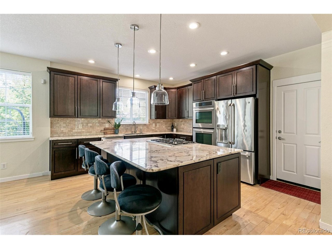 Nestled on a quiet cul-de-sac in the highly sought-after RedLeaf community, this beautifully maintained home offers the perfect blend of comfort, style, and low-maintenance living. Featuring 5 bedrooms, 4 bathrooms, and over 2,700 finished square feet, the flexible floor plan is designed for everyday living and entertaining.Step inside to soaring ceilings, abundant natural light, hardwood floors throughout the main and upper levels, and an inviting great room with a gas fireplace. The chef's kitchen features custom granite countertops, a Thermador gas cooktop, Jenn-Air double ovens, soft-close cabinetry, under-cabinet lighting, an oversized island, and pantry.The main-floor primary suite offers vaulted ceilings, a walk-in closet, and a luxurious five-piece bath. Upstairs, three additional bedrooms and a spacious loft provide flexible living space with seasonal mountain views. The finished basement adds an electric fireplace, heated bathroom floors, plumbing for a future kitchenette, and a versatile fifth bedroom or flex space.Outdoor living shines with a spacious Trex deck overlooking one of RedLeaf's most distinctive backyards, featuring grandfathered irrigated raised garden beds, mature landscaping, fruit trees, and a stunning willow tree.The HOA maintains the landscaping, irrigation, tree trimming, snow removal, trash, and recycling, allowing for truly low-maintenance living. Ideally located near Broomfield County Commons, Paul Derda Recreation Center, parks, trails, shopping, dining, and within the desirable Legacy High School attendance area, this home offers an exceptional lifestyle in one of Broomfield's most sought-after neighborhoods.