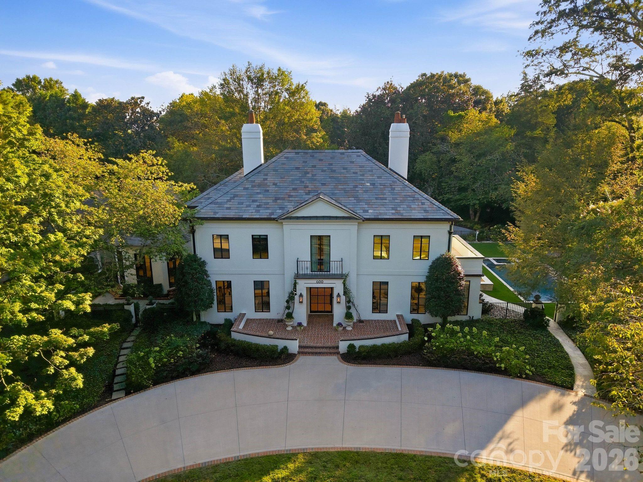 A rare opportunity to own a legacy estate in one of Myers Park’s most prestigious locations, just steps from the Duke Mansion. Privately situated on almost 1.3 acres, this exceptional property offers dual gated entrances, including a grand circular drive off Hermitage Road overlooking the original historic four-acre park, and a private 5-car garage motor court off Granville Road.  The residence has been extensively renovated and thoughtfully curated with exceptional finishes throughout, including Waterworks fixtures, Visual Comfort lighting, trimless recessed lighting, new 9 ¾” hardwood floors, aluminum clad windows, all new interior and exterior doors, steel accent windows and doors, updated HVAC systems, sealed crawl space and so much more.The property includes three separate structures: the light filled Main residence, renovated in 2023 by Pettus Builders offering 5 bedrooms and 6 baths, primary on the main and second primary up;  Detached two-car garage with a guest suite renovated in 2021 featuring a full bath, kitchenette and 2nd laundry most recently used as a gym; and then an additional Three-car garage with a flexible guest/bonus suite above.  This estate was designed for both entertaining and everyday living, the private grounds feature a pool and spa added in 2023, basketball/pickleball court (2020), covered outdoor entertaining area (with full bath and a separate kitchenette), baseball batting cage, putting green and expansive turf lawn added in the rear where the mature landscaping provides perfect afternoon shade. Meticulously maintained and carefully updated, this is one of those truly special Myers Park properties that rarely becomes available, offering privacy, acreage and resort-style amenities while still being within walking distance of neighborhood restaurants and shops and just minutes from Uptown and SouthPark.Please ask your agent for a complete list of renovations, upgrades and special features.