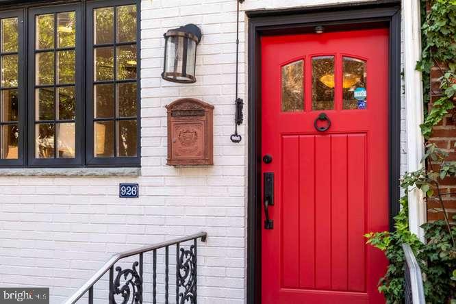 Welcome to 926 Catharine Street — a truly special Bella Vista home where historic character meets modern comfort. The handsome white brick façade and striking red door open into a charming foyer featuring original stained glass panels and a glass-paneled interior door. A large bay window floods the living room with natural light, creating an inviting space for relaxing or entertaining. The dining room includes a substantial hutch, and it flows seamlessly into the one year old open kitchen, beautifully updated with abundant cabinetry, quartz countertops, stainless steel appliances, and a beautiful custom wood breakfast bar. The original tin ceiling adds a touch of vintage charm. From the kitchen, step out to the slate patio — spacious enough for outdoor dining, gardening, and gatherings. From the Living Room go up the wood staircase to the second floor which offers an open den area, two bright and generously sized bedrooms with deep custom closets, and a full guest bath featuring a jetted tub, marble flooring, and a Euro style towel warmer. The third floor is a full-floor primary suite, complete with a marble-tiled bath, another Euro style towel warmer, and a sitting/dressing room with a wall of custom closets. Glass sliding doors lead to a large balcony, where you’ll enjoy fantastic skyline views. The finished lower level provides flexible space for a workspace or playroom, built-in shelving, an area ready for a powder room, a full-size LG washer/dryer, and a separate mechanical room with ample storage. A bonus exterior door offers convenient street egress.  Additional features include hardwood floors throughout, fabulous radiator heat, and a new roof. All of this is set on a lovely tree-lined street in the heart of Bella Vista — just steps from several parks, Whole Foods, the Italian Market, and an incredible selection of renowned restaurants.