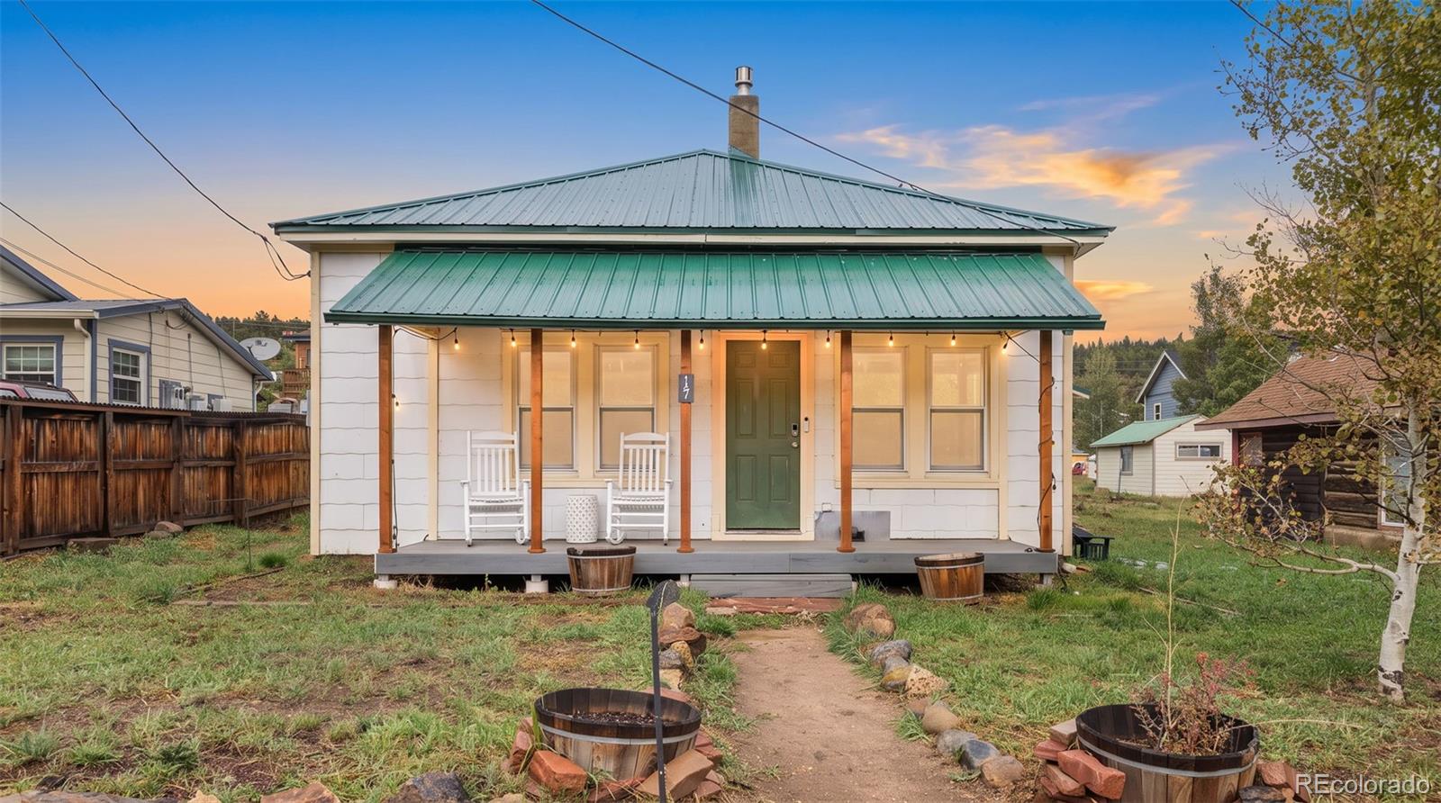 Live in the heart of idyllic Nederland in this charming 100-year-old bungalow, perfectly positioned on a flat double lot along one of town's main streets. Offering the best of mountain-town living, this single-story home is just a short stroll from restaurants, shops, grocery stores, live music, public transportation and Barker Reservoir, with easy access to nearby trails and just minutes from Eldora Ski Resort. A covered front porch welcomes you into a home filled with vintage character and mountain ambiance, with hardwood floors and an inviting open flow between the living and dining areas. A gas fireplace and wood stove add warmth and supplemental heat, while updated fixtures and thoughtful improvements provide modern convenience. The kitchen has been partially updated with newer cabinetry, stainless steel appliances and updated countertops. Adjacent to the kitchen, the remodeled full bathroom features a tub, while a large pantry and storage area provide valuable utility. Three generous-sized bedrooms provide comfortable space for family, guests or a home office if desired. A covered back porch leads to the fenced backyard, with alley access and an oversized attached 2-car garage that connects conveniently to the kitchen. Major improvements include a newer metal roof, updated windows throughout and an owned 8kW solar system installed in 2025. The flat double lot offers space and versatility rarely found in such a central location. This home retains the character and charm of a century-old Nederland bungalow while offering important modern upgrades and infrastructure. It is not completely turnkey and offers an opportunity for a buyer to add their own finishing touches and build upon the improvements already in place. A unique opportunity to own a piece of Nederland history with an unbeatable downtown location, valuable upgrades and plenty of potential.