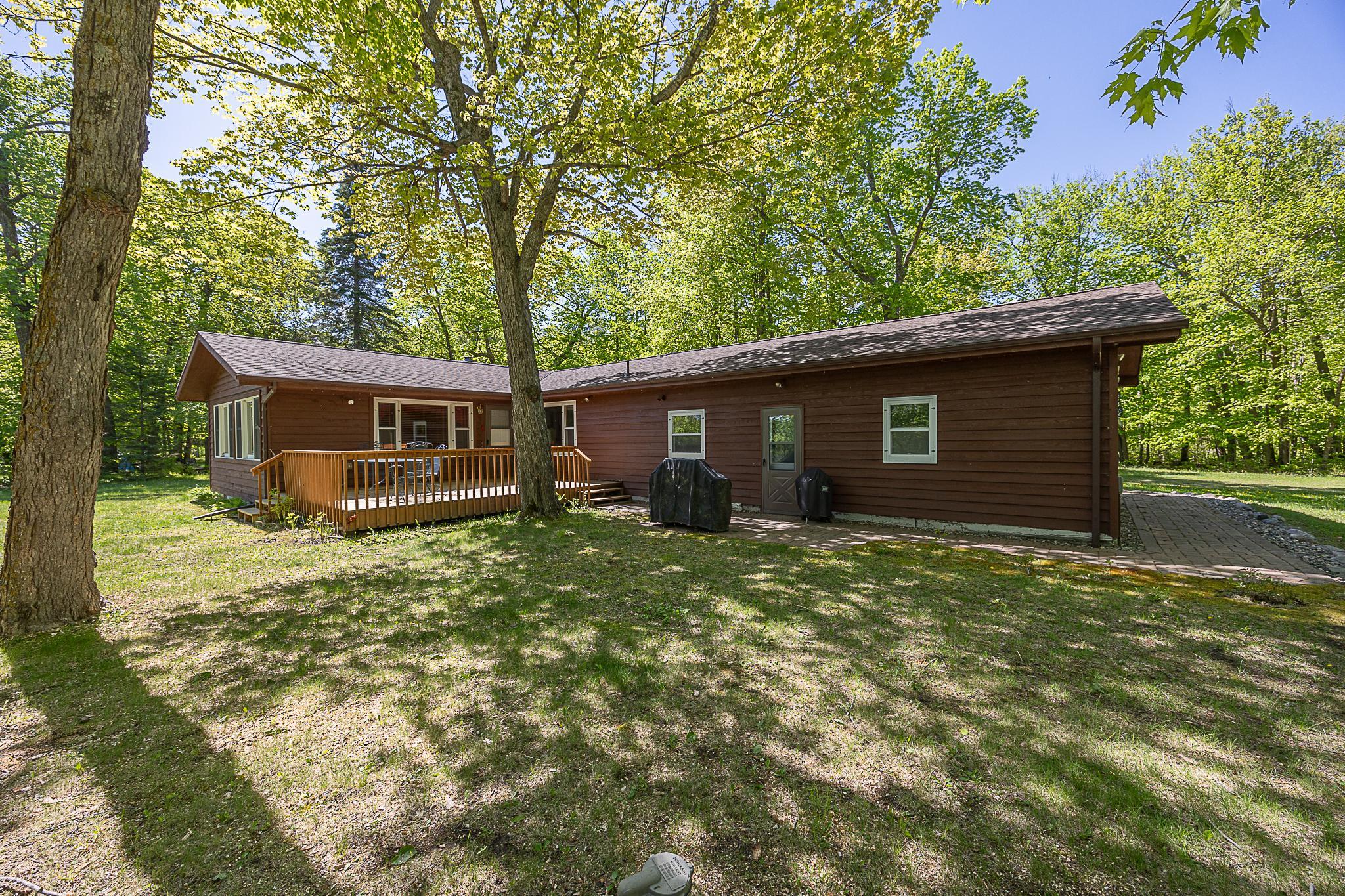 Welcome to your own lakeside retreat, tucked beneath mature trees and set on over 2 acres with 200 feet of shoreline on the peaceful and scenic Blackwater Lake. Step inside and you’ll be greeted by a warm, open atmosphere with wood floors, half-log walls, and a vaulted wood ceiling that soars above the family room. A stone fireplace with built-in wood storage creates a cozy focal point for gatherings, while expansive windows frame views of the surrounding landscape. The kitchen offers generous cupboard space and a convenient pass-through to the adjacent dining room which is ideal for entertaining or everyday living. With its own fireplace, the dining room is versatile enough to become a game room, lounge, or creative space. Both bedrooms are inviting with one featuring a walk-in closet. The home also includes extra storage space, a washer and dryer, and an attached garage with a bonus workshop area, great for projects, gear, and seasonal toys. Outside, a spacious yard gently slopes toward the lake, offering plenty of room for outdoor activities, garden plans, or simply relaxing on the deck as you take in the water views. This is a rare opportunity to own a private slice of Blackwater Lake with space to spread out, unwind, and make memories that last for generations.
