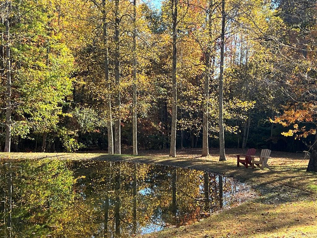 Gentle building lot with a 3-bdrm septic system in place, power and deeded water rights too! This tranquil 2.5-acre private lot is situated in the quiet gated community of Wolf Mountain Estates. Located just 18 miles from downtown Murphy, NC, this lot literally wraps around the community's common area pond in a picturesque, park-like environment. Did I mention it has west sunset views with a little tree trimming? This wooded sanctuary offers breathtaking views of the serene pond providing an ideal backdrop for your future home. Walk directly from your backyard to the pond and over to the Community Clubhouse across the street, which hosts outdoor picnic seating and a stone patio with a wood-burning fire pit and more! Enjoy this beautiful mountain lifestyle with friends, family and neighbors!  The seller has cleared a large section of the lot for easy showing and exploring.  A "house pad" has been leveled to show where your dream mountain cabin is ready to build! This lot is primed for your custom build, with protective restrictions in place to safeguard your investment. Enjoy the convenience of walkable trails and the peace of nature, just a short driving distance from Tennessee, Georgia and Murphy, NC. This is your rare opportunity to claim your slice of paradise—ready to build, easy to show and ready for your unique vision! Bring your contractor with you to tour. This property has everything your looking for - Don't let this unique gem slip away!