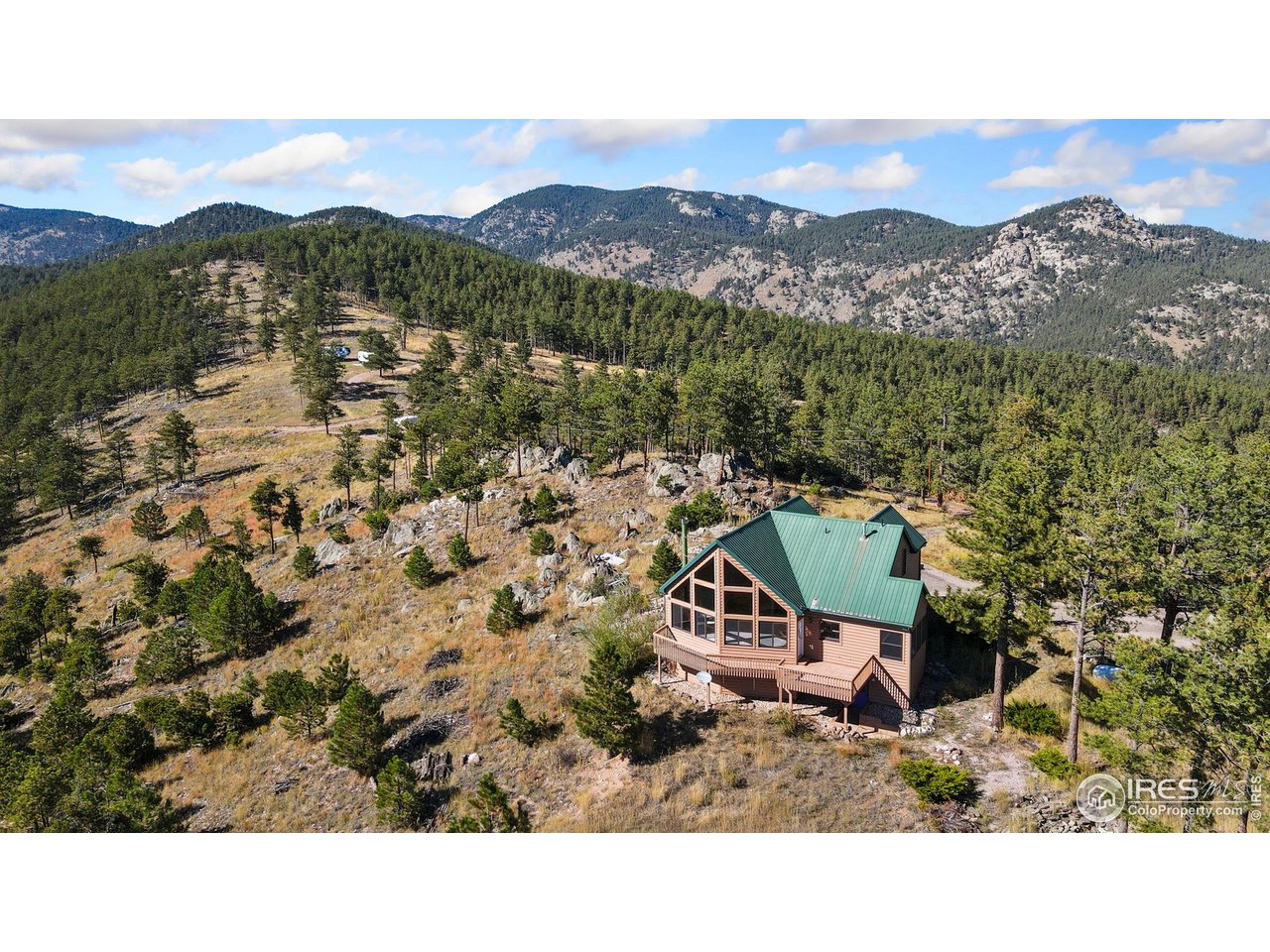 Ready to own your slice of beautiful Colorado? Welcome to 965 Stone Mountain Ranch Rd, a private mountaintop retreat perched on over 48 acres with sweeping views of Pinewood Reservoir and the Front Range. This beautifully crafted cabin blends rustic charm with modern comfort, featuring a durable metal roof, floor-to-ceiling windows, a wraparound deck, and endless serenity. Enjoy main floor living with two bedrooms, a spacious kitchen, and a bright, airy living area. The spacious loft can easily convert to a third bedroom with an ensuite. Just steps away from the home, a massive 1,900+ sq ft outbuilding provides space for cars, campers, and all your mountain toys. Step outside to newly fire-mitigated grounds, a water feature, and multiple sitting areas where wildlife and breathtaking sunsets are your neighbors. Just minutes from hiking, boating, and camping, yet still a convenient drive to town, this home offers the perfect balance of adventure and everyday life. It is truly Colorado living at its finest. Schedule your showing today! Please note, the property is on a private road, please do not drive by without an appointment.