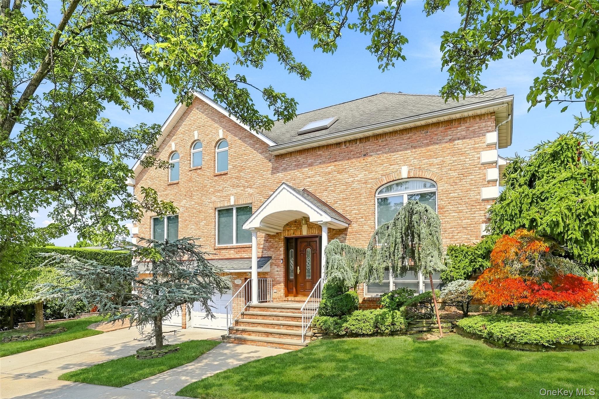Welcome to 53-15 Overbrook Street, an impressive brick residence built in 1999, offering nearly 4,000 square feet of living space in one of Douglaston's most coveted locations. Situated on a beautifully landscaped corner property, this substantial home offers an abundance of natural light, generous room sizes, and a versatile multi-level layout ideal for both everyday living and entertaining. The home features spacious living and dining areas, a fireplace, crown moldings, hardwood and tile flooring, and an oversized eat-in kitchen with granite countertops, extensive cabinetry, and stainless steel appliances. Recent upgrades include a new double oven, dishwasher, range hood, washer and dryer, new heating system, and reverse-osmosis water filtration system. Large windows throughout create a bright and welcoming atmosphere, while the fully finished basement with a separate outside entrance provides substantial additional space and flexibility. Complete with beautifully maintained landscaping, excellent curb appeal, and an exceptional amount of interior space, 53-15 Overbrook Street offers a rare opportunity to own a well-maintained home in one of Douglaston's most desirable residential neighborhoods.