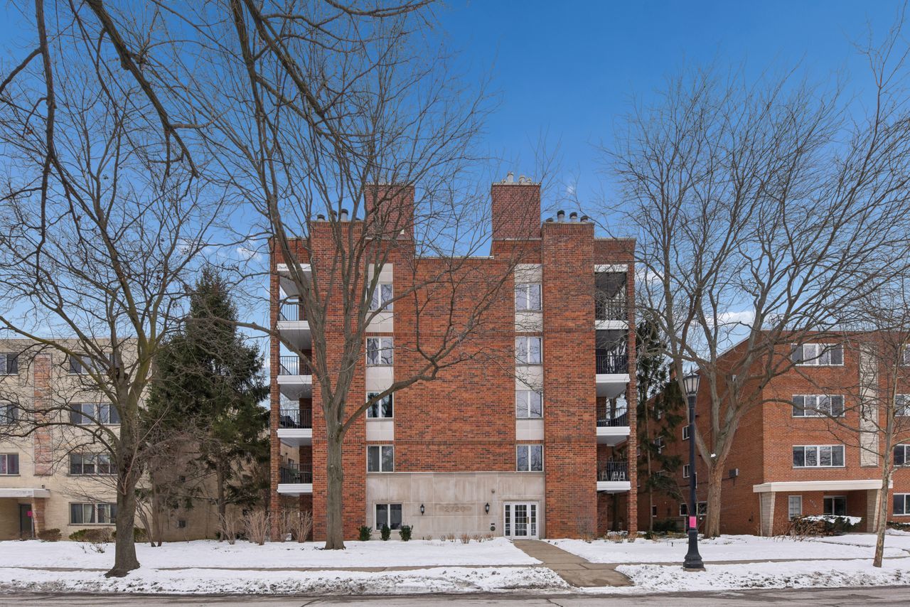 The Perfect Condo! Beautiful 2 bedroom 2 bath unit on the top floor with wonderful tree top views. Great floor plan with easy flow pattern. The spacious living room has vaulted ceiling and lovely fireplace with dining area adjacent. Features include eat-in kitchen, wood laminate floors throughout, in-unit washer/dryer and individual heat and AC. The balcony off the living room is perfect for entertaining and grilling.Large primary suite with lots of closets including a walk-in with built-in drawers and shelves. Unit includes storage locker and 2 parking places - one in the heated garage and one in the outdoor parking pad. This is a very well maintained elevator building in a terrific location. Close to transportation, shops, restaurants and more. A Must See!