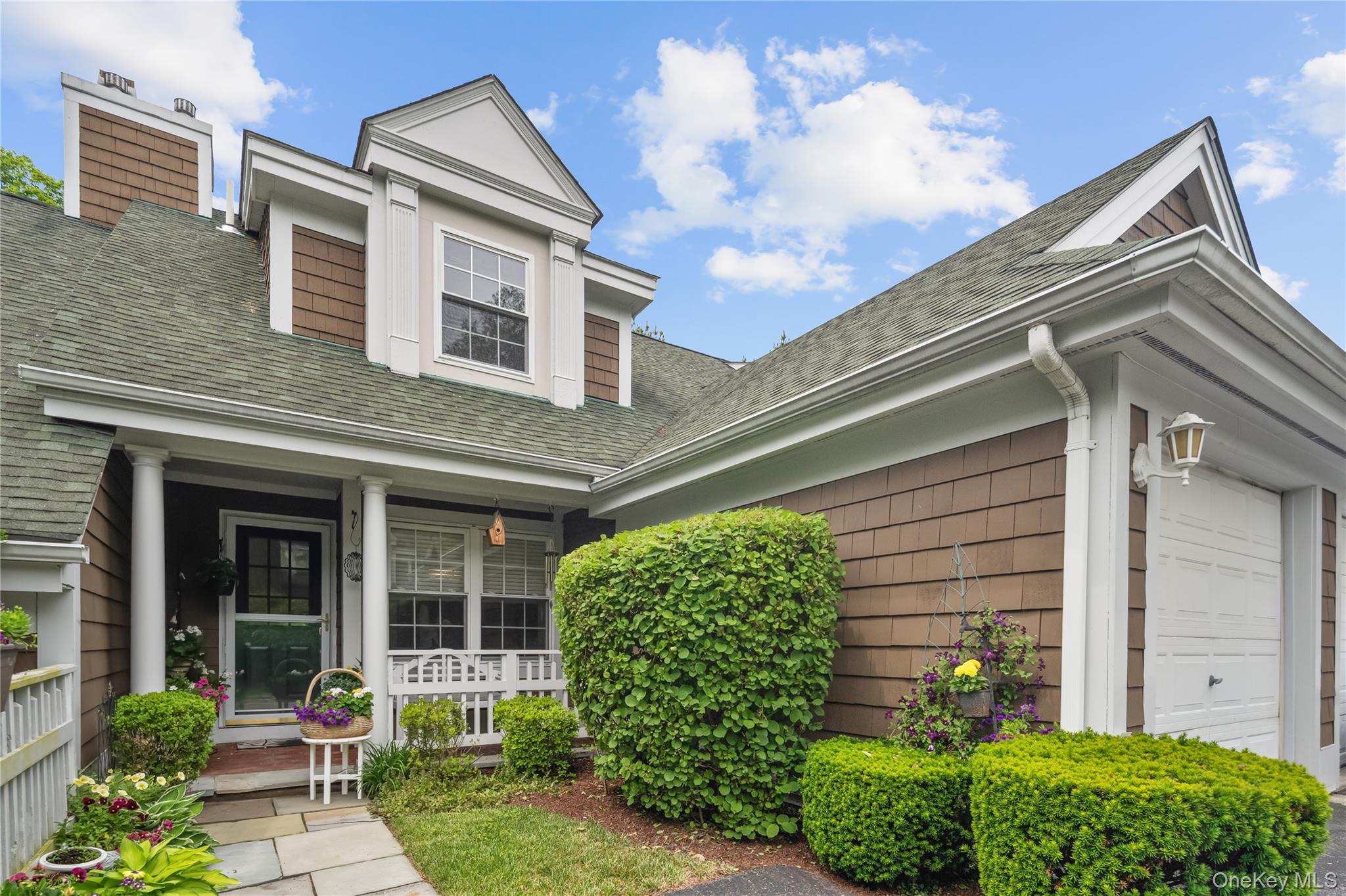 Welcome to 4 Winterberry Lane, a beautifully updated townhouse tucked away on a quiet cul-de-sac in the highly sought-after Wyndcrest community. This move-in ready 2-bedroom, 2.1-bath home with a loft and finished lower level offers the perfect blend of style, comfort, and convenience in the heart of Briarcliff Manor. Ideally located just moments from the village, restaurants, shopping, parks, scenic walking and biking trails, Club Fit, and major transportation, Wyncrest residents also enjoy wonderful community amenities including a pool, basketball court, and playground. From the moment you enter, the home showcases warmth and sophistication with stunning Brazilian wood flooring and a light-filled open layout designed for both everyday living and entertaining. The beautifully renovated eat-in kitchen features limestone countertops, marble backsplash, glass-front cabinetry, built-in wine rack, pantry with pull-out shelving, custom shades (2026), and premium stainless steel appliances including KitchenAid double wall ovens, Bosch Dishwasher and a Wolf 4-burner gas cooktop. The spacious living and dining area is filled with natural light from two skylights and sliding glass doors leading to a private wood deck perfect for relaxing or entertaining. Upstairs, the versatile loft offers ideal flex space for a home office, den, or reading area, while the bedroom level features oak and Brazilian wood flooring throughout. The serene primary suite includes generous closet space and a beautifully updated en-suite bath with dual-sink vanity and walk-in shower. A spacious second bedroom and updated hall bath complete the upper level. The finished lower level adds tremendous flexibility with a large recreation room featuring sliding glass doors to the backyard along and storage space. Additional highlights include upgraded closets throughout, a one-car attached garage with shelving, and an additional assigned parking space. Combining stylish updates, flexible living space, resort-style amenities with low maintenance fee, and an unbeatable cul-de-sac location, this exceptional home offers the lifestyle today’s buyers are looking for.