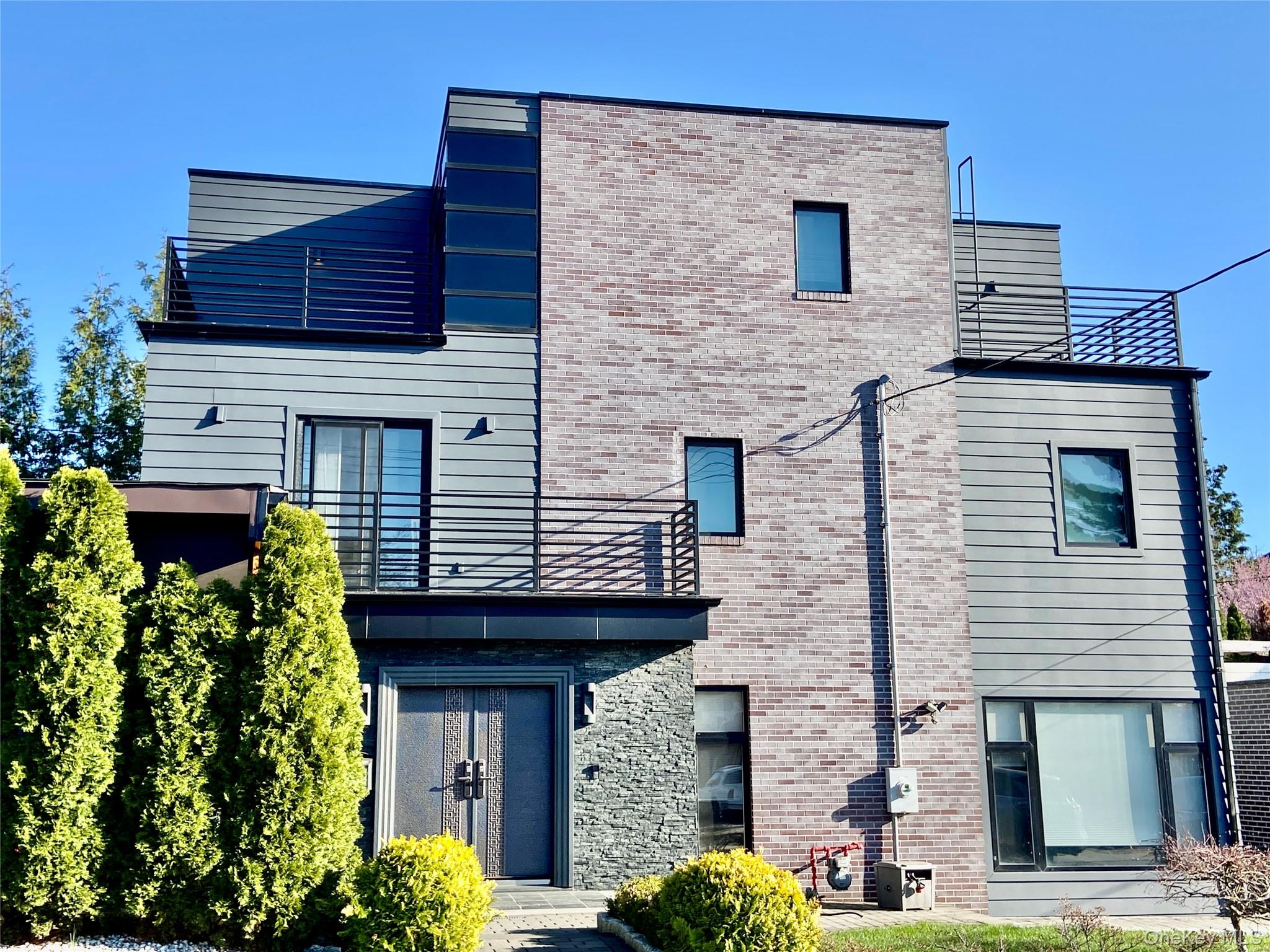 Stunning modern contemporary home with a sleek cubic design, showcasing a striking blend of brick, stone, and horizontal siding. Clean architectural lines, flat roof, and expansive windows create a bold and upscale presence. Finished with modern metal railings and thoughtfully designed outdoor spaces, this home offers both style and functionality. This custom-built luxury residence, built in 2012, offers approximately 2,412 sq ft of interior living space, with a total zoning floor area of approximately 3,862 sq ft.The home features 5 spacious bedrooms and 4.5 bathrooms, thoughtfully designed for both comfort and refined living. The gourmet chef’s kitchen is equipped with high-end Miele appliances and a LG refrigerator, perfect for both everyday use and elevated entertaining. Radiant heated floors in all bedrooms and  living & dinning room.The primary suite offers a walk-in closet, private balcony, and a luxurious spa-like bathroom complete with a steam room, creating a true retreat.Outdoor living is thoughtfully designed with a covered entertaining pavilion, complete with a barbecue station and built-in sink, creating the perfect setting for outdoor cooking, dining, and gatherings. The covered structure allows for comfortable year-round use, making it an ideal extension of the living space.Additional highlights include custom floating stairs, imported natural stone finishes throughout, a striking chandelier centerpiece, central air conditioning, a finished basement, and a detached garage with electric door and driveway. Conveniently located near shopping, dining, and transportation, with easy access to Northern Boulevard. Walking distance to Little Neck train station.A rare opportunity to own a truly distinctive luxury home in a prime Little Neck location.