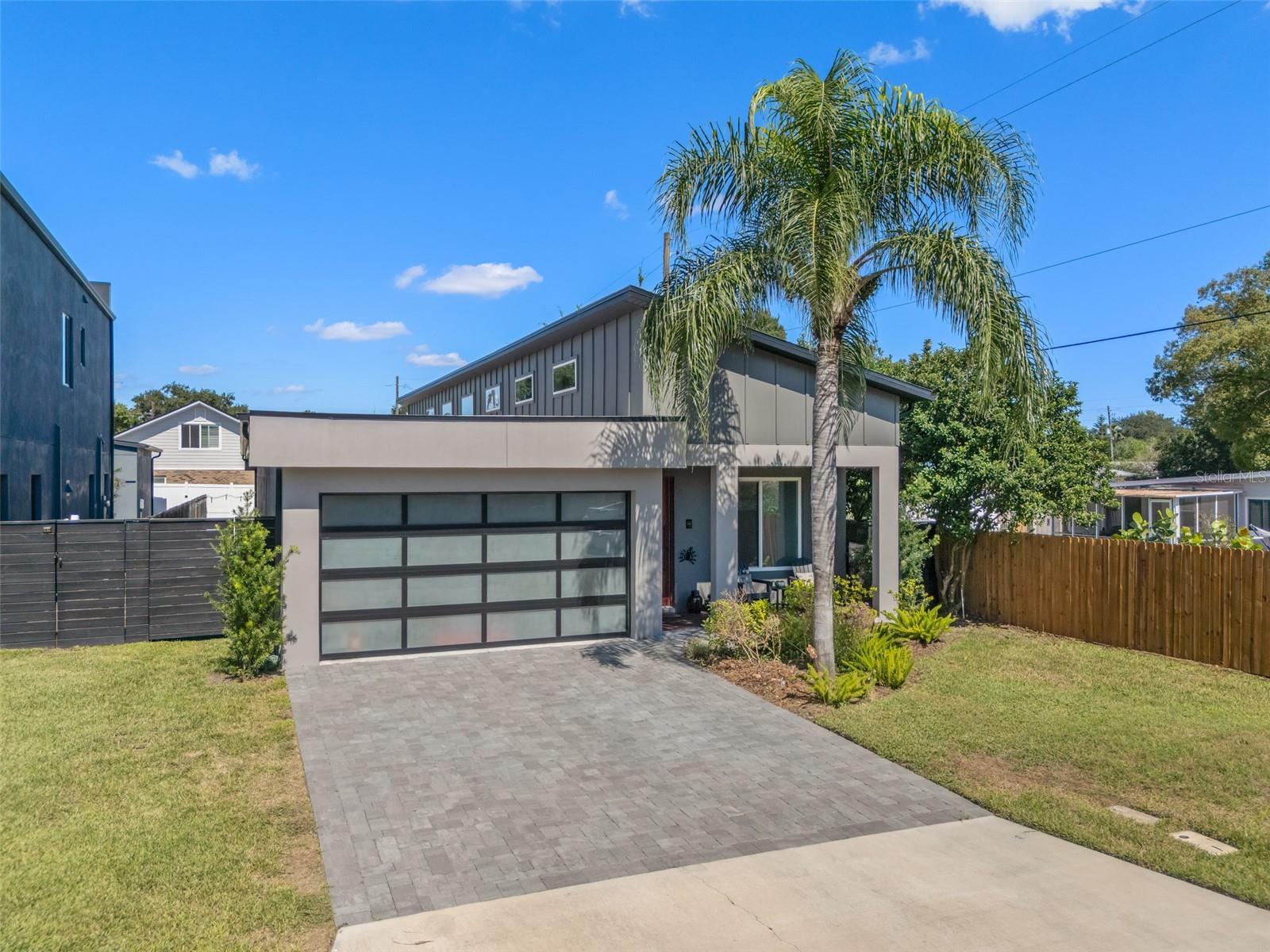 Modern Luxury Meets Everyday Comfort in the Heart of the Hourglass District

Welcome to this stunning modern build by Hourglass Homes — a bright and stylish retreat in one of Orlando’s most vibrant neighborhoods. Bathed in natural light from its dramatic roofline of windows, this nearly new home showcases thoughtful design and high-end finishes throughout. From the moment you step onto the wood-accented front porch, you’ll feel the care and craftsmanship that define this exceptional property.

Inside, the flexible 4-bedroom layout offers space to live, work, and relax — including a custom built-in bookshelf and cabinetry in one of the bedrooms, perfect for a home office or cozy retreat. All walk-in closets feature custom-built shelving for seamless organization, while LED cabinet lighting adds warmth and ambiance to the kitchen and bathrooms. The chef’s kitchen stuns with stainless steel appliances, quartz countertops, and designer finishes — a true centerpiece of the home.

The primary suite is a spa-like escape with dual rain showers, Bluetooth-enabled exhaust fans, and elevated quartz vanities. Additional perks include high-efficiency AC, spray foam insulation, LED lighting throughout, and no HOA.

Car lovers will be thrilled by the enthusiast’s garage, complete with SwissTrax flooring, a workbench, EV plug-in, and sleek honeycomb lighting for both function and flair.

Enjoy outdoor living on the screened-in back patio, accented with wood flooring panels, perfect for Florida evenings.

This lovingly maintained home is move-in ready and

waiting for its next chapter. Whether you're entertaining, unwinding, or simply living in style, this home delivers it all — comfort, efficiency, and location. Just minutes from local shops, cafes, and downtown Orlando, convenience meets charm in the sought-after Hourglass District.

Don't delay — call today!
