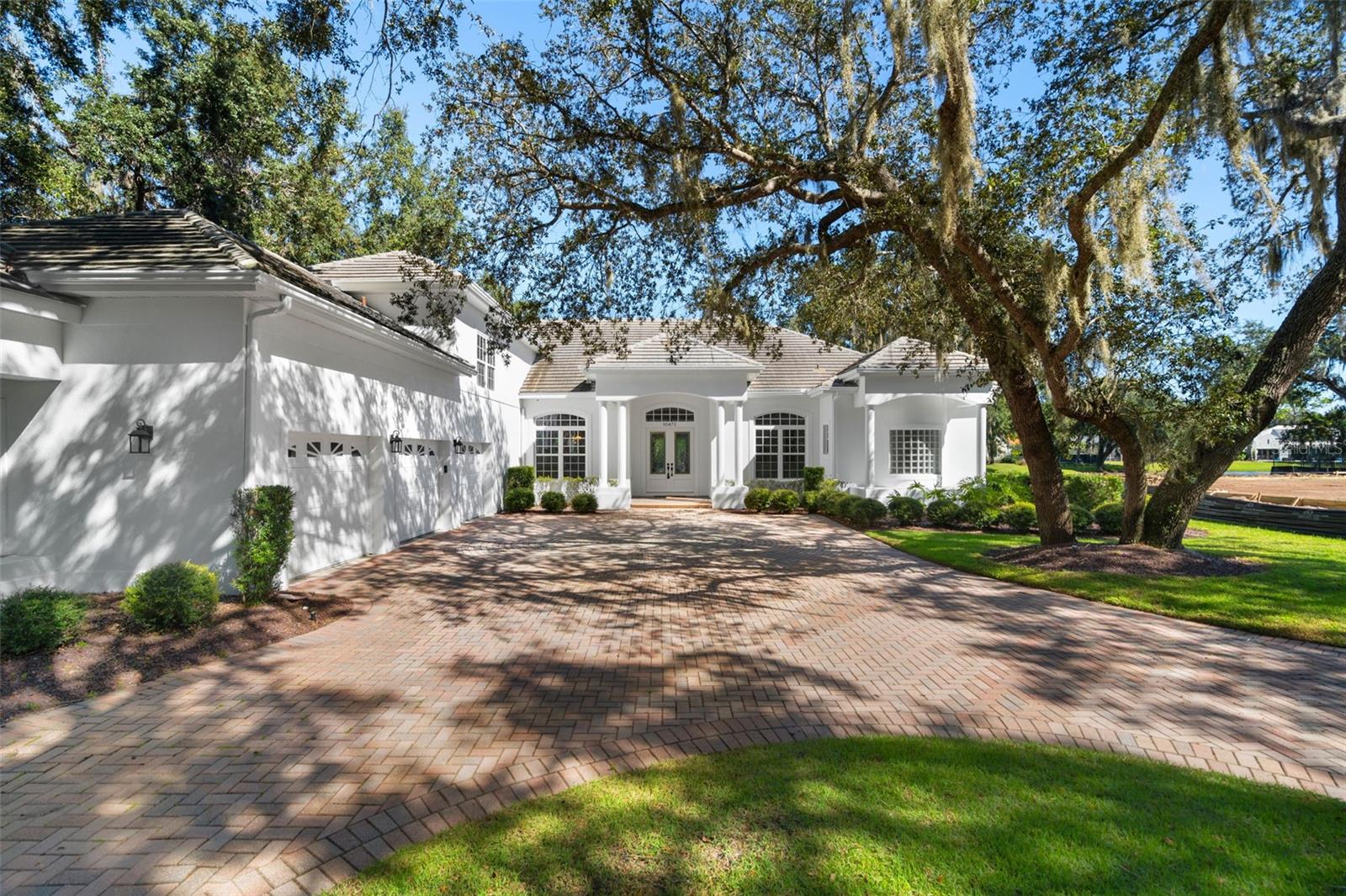 Beautifully renovated residence tucked away on one of the most private and tree-lined streets in the prestigious Lake Nona Golf & Country Club. Set on an oversized lot with mature landscaping and tranquil partial pond views, this elegant home blends timeless design with modern sophistication.A circular paver driveway leads to a rare 4-car garage, offering impressive curb appeal and generous guest parking. Inside, the open floor plan is filled with natural light and features travertine flooring, custom millwork, and a stone wood-burning fireplace. The new gourmet kitchen showcases white quartz countertops with waterfall edges, Sub-Zero wine storage, Thermador gas cooktop, KitchenAid refrigerator, and designer cabinetry.The primary suite features wood floors, coffered ceilings, dual walk-in closets, a spa-style bath with garden tub and walk-in shower, and direct pool access with peaceful backyard views.Outdoor living includes a private pool and heated spa, surrounded by tropical landscaping and a fenced yard that offers both comfort and openness. The covered patio is prepped for a future summer kitchen, providing an ideal space for relaxing or entertaining.Additional highlights include a versatile upstairs guest suite or bonus room with private bath and breakfast bar, a study or 3rd bedroom with pool bath access, and a second main-level suite.Recent updates include new AC systems (2025), new water heater (2025), new kitchen cabinetry and quartz countertops (2024), and modern LED lighting throughout. Offered fully furnished by MAX Home Design, this move-in ready home presents exceptional value within one of Orlando’s most exclusive gated communities—featuring a Tom Fazio golf course, clubhouse dining, fitness center, tennis courts, and 24-hour security.Experience resort-style living in Lake Nona Golf & Country Club, just minutes from Medical City, UCF Lake Nona Hospital, and Orlando International Airport.