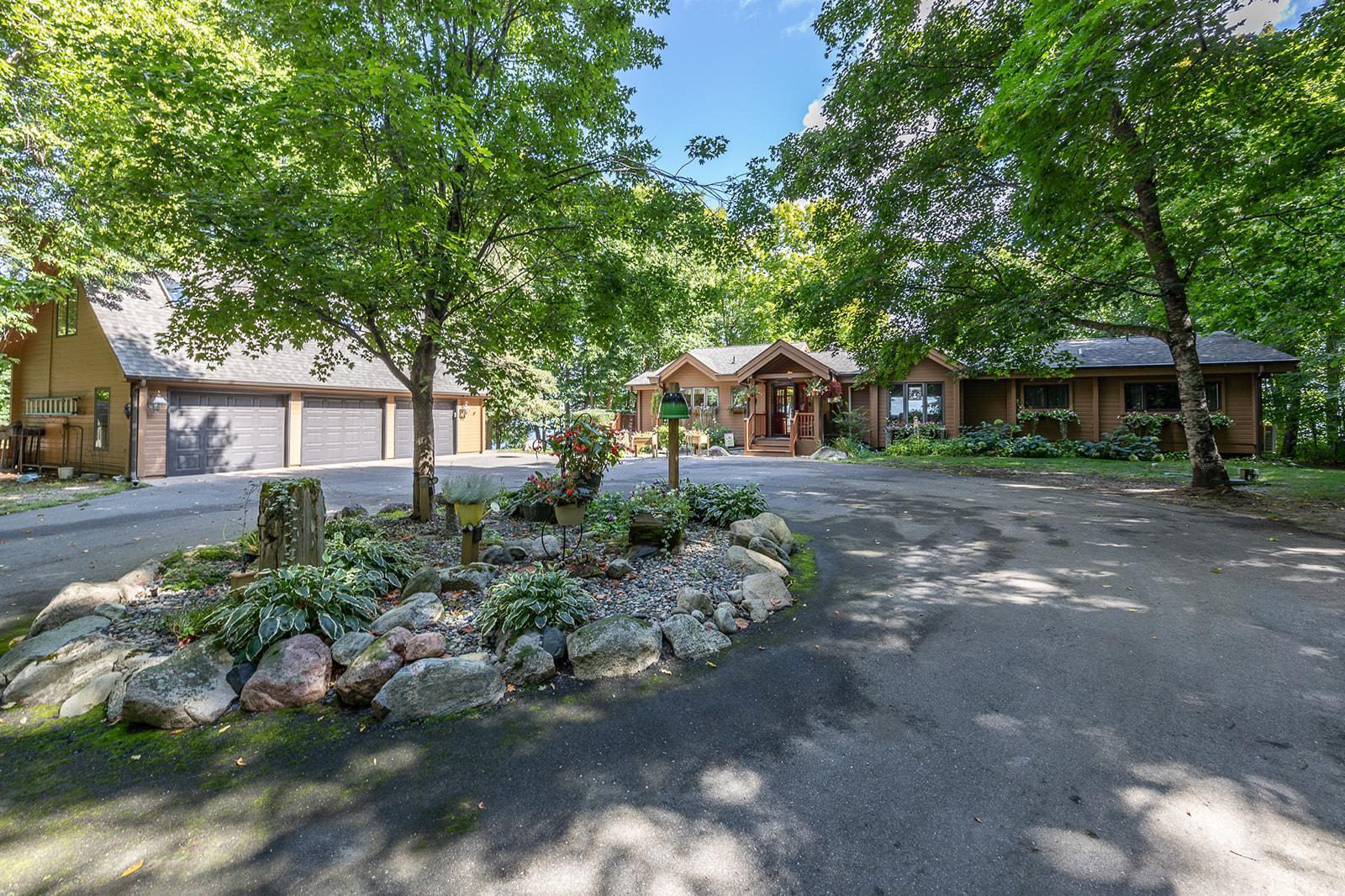This is an excellent opportunity to live on beautiful Spain Point on the coveted Woman Lake Chain, where you can enjoy 189 feet of shoreline and 1.25 acres of privacy. In 1973, a remarkable log home was crafted in Sweden, where master carpenters meticulously fit each log so precisely that no chinking was needed to seal the gaps. This architectural marvel was then carefully dismantled, transported across the Atlantic, and reassembled in Minnesota. Years later, the home underwent another transformation as it was lifted from its original foundation, allowing for a new, sturdy base to be laid and additional rooms to be seamlessly integrated into the structure. This blend of old-world craftsmanship and modern expansion has created a unique home that is a testament to timeless design and enduring quality. Upon entering the home, you will be captivated by its centerpiece—a see-through stone, wood-burning fireplace elegantly positioned between the kitchen and the great room. The great room’s cozy fireplace and bay window bring warmth and natural light. Enjoy lake views from the large windows or step outside onto the massive wrap-around deck to watch the sunrise. The screened porch, which covers you in vaulted wood ceilings and skylights, has direct access to the owner’s suite and the office, allowing you to fall asleep or work to the soothing sounds of the lake. The kitchen is thoughtfully designed, with an island and desk area that opens to the dining room that displays whole beam ceiling accents. The lower level features a walkout family room with a second wood-burning fireplace, a bedroom, a bathroom, and abundant storage space. There’s also direct access to the tuck-under garage, perfect for storing off-season toys. The 3-car insulated garage has a heated/cooled bonus room with skylights that bring in natural light. This is an excellent place for another office or workout room. The outdoor offerings of this property are unparalleled. Explore the beautifully landscaped grounds, which include custom paved walkways, flower gardens, and tranquil paths that invite peaceful exploration. Woman Lake is part of a chain of lakes that include Girl and Child. This beautiful lake country also features multiple trail systems for year-round enjoyment, such as biking, hiking, and snowmobiling.