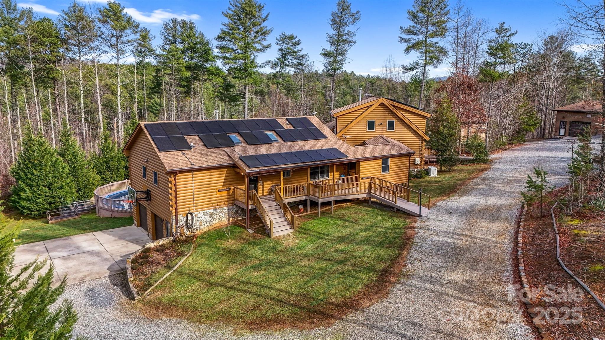 Multigenerational mountain farm steps from being off grid! 2 log homes w/separate utilities, a bunk house & 2 camper sites! Start making money immediately or set up the perfect retreat! This well thought out homestead features the main home with 4 bedrooms, 3 baths & a sunroom/breezeway to connect to 2nd log home. 2nd home has 2 bedrooms, 2 baths & basement garage. Walk out basement has a 3rd bathroom attached to what could be transitioned to a self contained 3rd unit. Pool and hot tub outside the walkout basement. Both homes feature screened in back porches & wood stoves. There is a bunkhouse with bathroom, workshop with 8th bathroom on this property, chicken coop with run, greenhouse, raised beds, compost bins & stunning stone firepit. Creek borders the property.  2 covered camper areas are wired & plumbed. Solar panels & generators are in place to assist with all backup needs. Neighborhood allows direct access to Pisgah National Forest. Please note HOA dues are for road mntnce only!