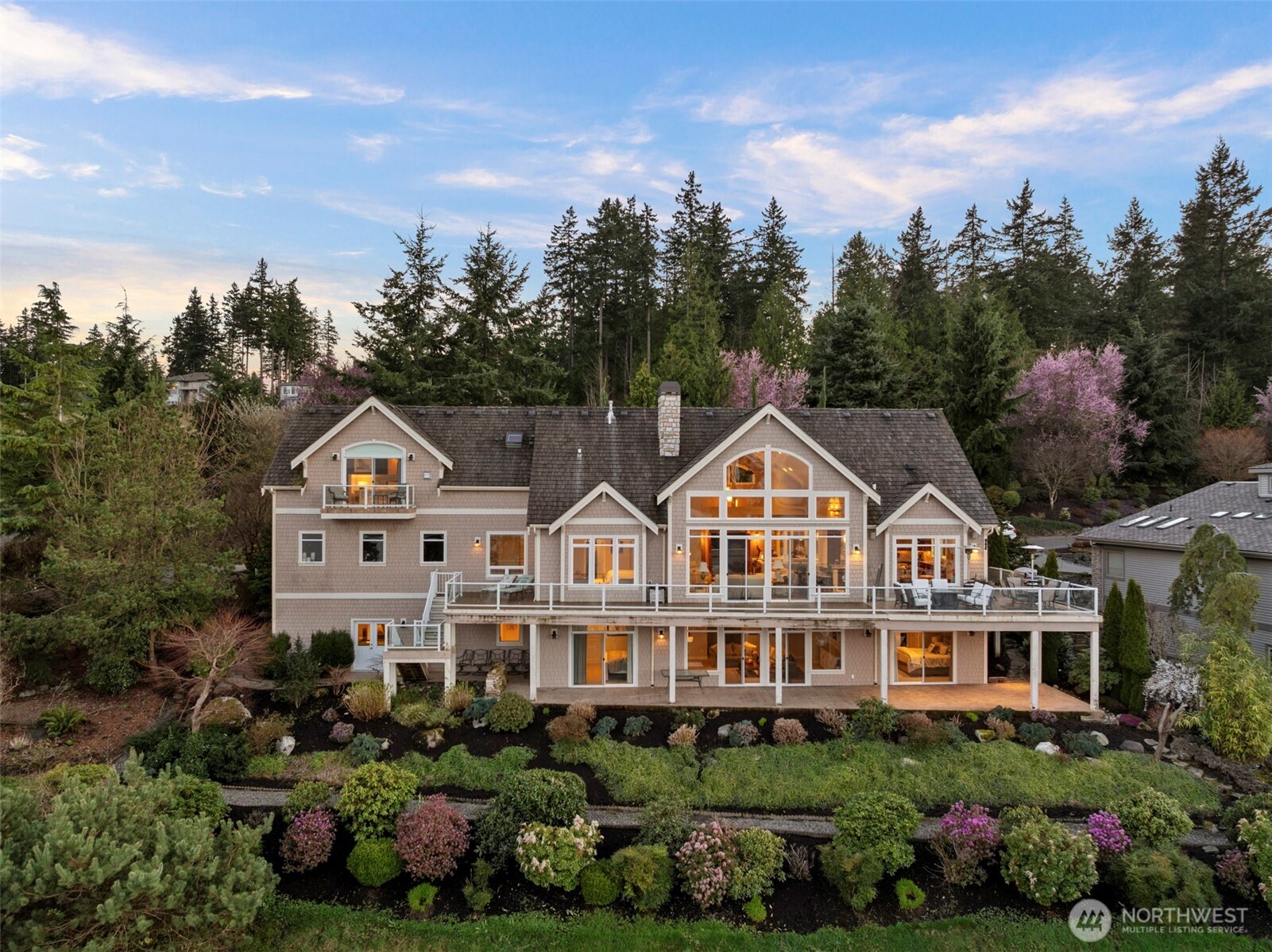 Experience the pinnacle of coastal luxury in this one-of-a-kind masterpiece where every room offers a front-row seat to breathtaking views of Drayton Harbor and the Canadian Rockies. Designed with an emphasis on sophisticated comfort, the heart of the home is a spacious custom kitchen featuring expansive granite countertops, premium stainless appliances, and cozy heated tile flooring. The seamless flow leads you into a formal dining room perfectly suited for grand-scale hosting. This thoughtful floor plan places the primary suite and laundry conveniently on the main level, while the upper level serves as a true sanctuary for guests, boasting a private suite with its own balcony and fireplace. Every one of the four bedrooms is a private retreat, complete with its own stunning view and en-suite bathroom featuring heated floors. For the ultimate entertainer, the cinema and recreation room comes equipped with a wet bar, complemented by integrated speakers and scenic lighting throughout the property for effortless ambiance. Modern peace of mind is ensured with a full ADT security system already in place. Whether you are enjoying the lush indoor spaces or the sprawling outdoor entertaining areas, the panoramic beauty surrounding this home is so spectacular you will have to pinch yourself every time you look out the window. This is more than just a home; it is the lifestyle upgrade you have been waiting for in a location that simply cannot be duplicated.