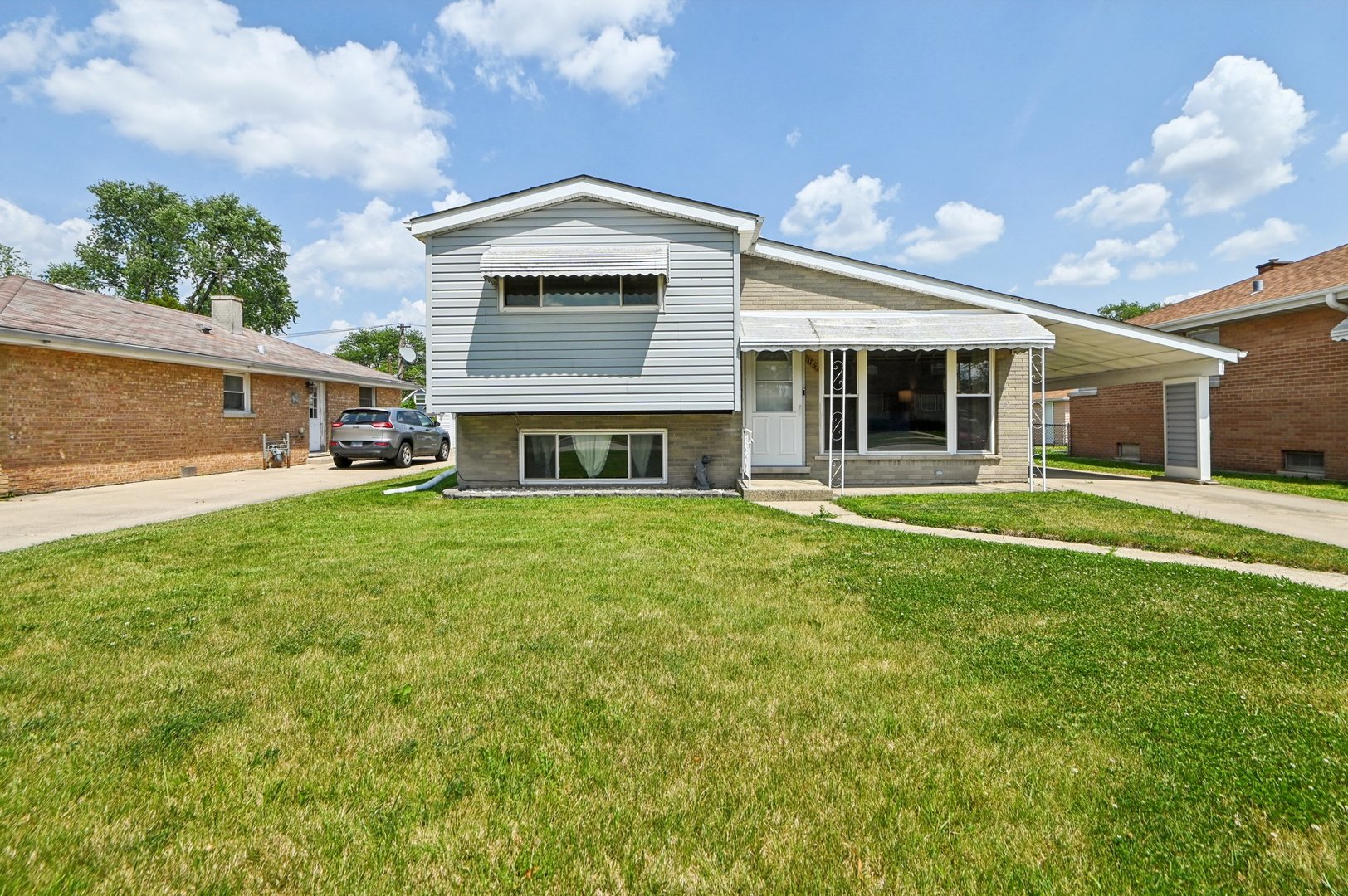 Charming split level home with vaulted ceilings and a nice open floor plan. Updated wood laminate flooring throughout the main level. Eat-in kitchen has a SS refrigerator, oven range and hood, quartz countertop, sink and faucet. Plenty of cabinetry for storage and a pantry. The spacious living room has a big picture window and open views of the kitchen and second level. Three bedrooms on the second level share a full bathroom. Great in-law or extended family arrangement on the lower level with a family room, kitchenette, and full bath with a shower. Most recent updates include - Windows (11 yrs), furnace (6 yrs), and roof is less than 4 years old. Driveway leads to an oversized 2.5 car garage with a separate attached storage shed. Metra station is 2 blocks away and expressway is less than a mile.