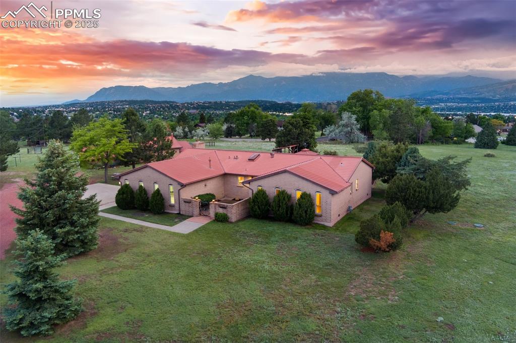 Amazing opportunity on an expansive lot with breathtaking, unobstructed views of Pikes Peak and the entire Front Range. This unique property offers limitless potential in a serene, mature neighborhood tucked right in the heart of town. The main residence features four bedrooms, fresh paint touchups, and brand-new carpet. A spacious kitchen with skylight and stainless steel appliances opens to a dedicated dining room with a bay window perfectly framing the mountain view. The sunken great room with radiant floor heating and cozy fireplace offers an inviting atmosphere and opens to a rear patio complete with a gazebo and covered grill area—ideal for entertaining and outdoor living. The master suite includes a private ¾ bath with a brand-new shower and direct walk-out access to a mountain-view patio. Two total baths in the main house, plus a large laundry room for added convenience. The finished and heated oversized two-car attached garage includes windows for natural light and added functionality. A charming entry courtyard adds to the home’s character and curb appeal. In addition to the main home, the property boasts a detached living quarters with a full kitchen, full bath, wood stove, laundry space, and an attached workshop—ideal for multi-generational living, guests, or rental income. A separate barn/workshop approximately the size of a two-car garage provides extra storage or project space. The expansive, level lot offers large fenced in area, plus ample space for additional outbuildings, sport courts, gardens, or whatever your vision may be. A rare combination of space, views, location, and versatility with unmatched potential and privacy. Located in esteemed Academy District 20 near hiking, biking, shopping, dining, all area amenities and convenient access to I-25 for an easy commute anywhere in town or Denver – this awesome property only feels miles away from it all! Don’t miss this rare opportunity! Schedule your showing today!