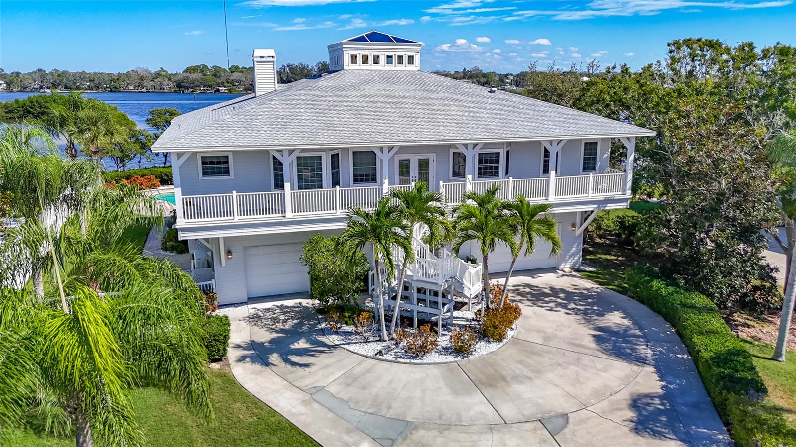 Discover a rare blend of coastal elegance, privacy, and modern design in this newly remodeled waterfront estate set on an elevated double lot along the scenic Anclote River. Built for both luxury living and resilience including a new roof in 2021, this home remained dry and undamaged through recent hurricanes, offering peace of mind and enduring value. 

Step inside to a bright, open-concept living area crowned by a lantern-style cupola that bathes the interior in natural light. Twelve-foot ceilings and expansive glass pocket doors create a seamless flow between indoor and outdoor living. The screened second-story veranda offers panoramic views of the tranquil cove and river—perfect for morning coffee or sunset gatherings by the cozy glass-front fireplace.

The spacious chef’s kitchen is equipped with premium Café Series appliances, including an Induction Café Series cooktop and Advantium Café Series built-in ovens, along with a Sub-Zero refrigerator, farmhouse sink, and striking black granite countertops reminiscent of river rock that complement custom cabinetry.

Retreat to the luxurious master suite upstairs, featuring an oversized his and hers closets and a fully remodeled spa-style bath with designer finishes.

Downstairs, a private mother-in-law suite includes a full kitchen, making it ideal for guests or multigenerational living. The four-car garage provides ample storage for vehicles, water toys, and more, while an elevator offers effortless access to all levels.

Step outside to enjoy lush tropical landscaping, a large paver sundeck, and a sparkling swimming pool overlooking the water. The new dock installed in 2021 features two lifts, fresh water and a fish cleaning station. Located just inside the mouth of the Anclote River, there is easy access to the Gulf, island beaches, and waterfront restaurants just minutes away.

Whether entertaining or unwinding in your own sanctuary, this home offers the best of Florida waterfront living—light, space, privacy, and luxury in every detail.

Additional upgrades include: new water heater 2023, reverse osmosis system with filter under kitchen Sink, and outdoor shed to convey.