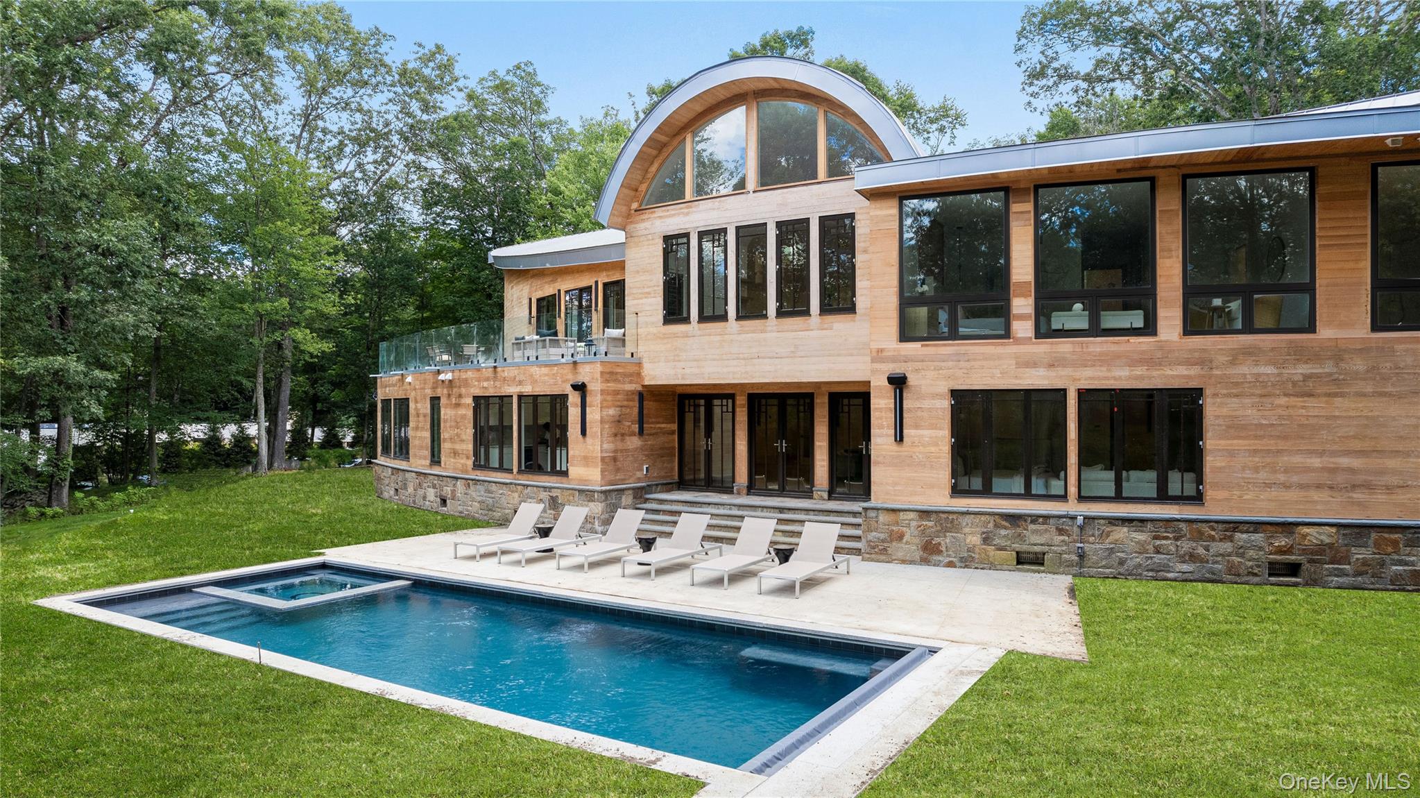 Welcome to 16 Col Sheldon, a newly completed and designer finished modern masterpiece set on four private acres in the heart of Pound Ridge. This stunning 5-bedroom, 6.5-bath home combines cutting-edge design with luxurious comfort, offering the ultimate in indoor-outdoor living.

Step inside to soaring 23-foot ceilings and a light-filled open-concept layout, perfect for both everyday living and entertaining. The chef’s kitchen is a showstopper, featuring a 48-inch Wolf range, Sub-Zero refrigerator, wine fridge, and seamless flow to the upper deck overlooking the picturesque property.

Every bedroom is ensuite, including a separate guest or nanny suite with its own private living room. The lower level is an entertainer’s dream—complete with a home theater, gym, office, and expansive lounge that opens directly to the pool area for effortless indoor-outdoor enjoyment.

Sonos speakers throughout the home provide a fully integrated experience, while the beautifully landscaped grounds and sleek pool create your own private retreat just an hour from NYC.

This is modern living at its finest—thoughtfully designed, impeccably executed, and perfectly placed.