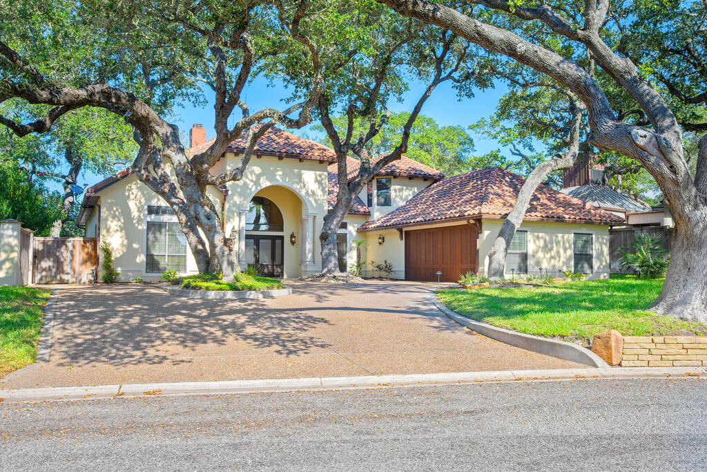 Mediterranean elegance meets exceptional waterfront living at 2505 Turkey Neck Circle. Set among mature oaks and tropical landscaping in Harbor Oaks, this remarkable residence offers sweeping water views, deep water access, and a prime location in the heart of Rockport. Offered below appraised value with furniture included, it presents an extraordinary opportunity to enjoy coastal luxury from the moment you arrive.  With approximately 4,416 square feet, four bedrooms, and four-and-a-half baths, the home provides generous space for family and guests. Soaring ceilings and expansive windows create an impressive setting for entertaining, while a fireplace, wet bar, and separate study add comfort and sophistication. The beautifully appointed kitchen features a substantial island, gas cooktop, double ovens, wine cooler, and two pantries, complemented by a formal dining room.  The downstairs primary retreat offers private outdoor access and an indulgent bath with a jetted tub, separate shower, dual vanities, and custom walk-in closet. Upstairs, three bedrooms with private baths accompany a second living area, kitchenette, and balcony—an inviting arrangement for extended visits and relaxed gatherings.  Outside, a screened porch and pergola invite leisurely afternoons overlooking the water. A boat lift, tackle room, and fish-cleaning station enhance the waterfront lifestyle, with room for your offshore boat and deep water access for your next adventure.  Enjoy the ease of being close to Rockport's restaurants, shopping, and coastal attractions, with Fulton Beach Road just a short golf cart ride away for sunrise outings and sunset cruises. Abundant upgrades, gracious Mediterranean character, and fabulous water views make this an exceptional place to call home.