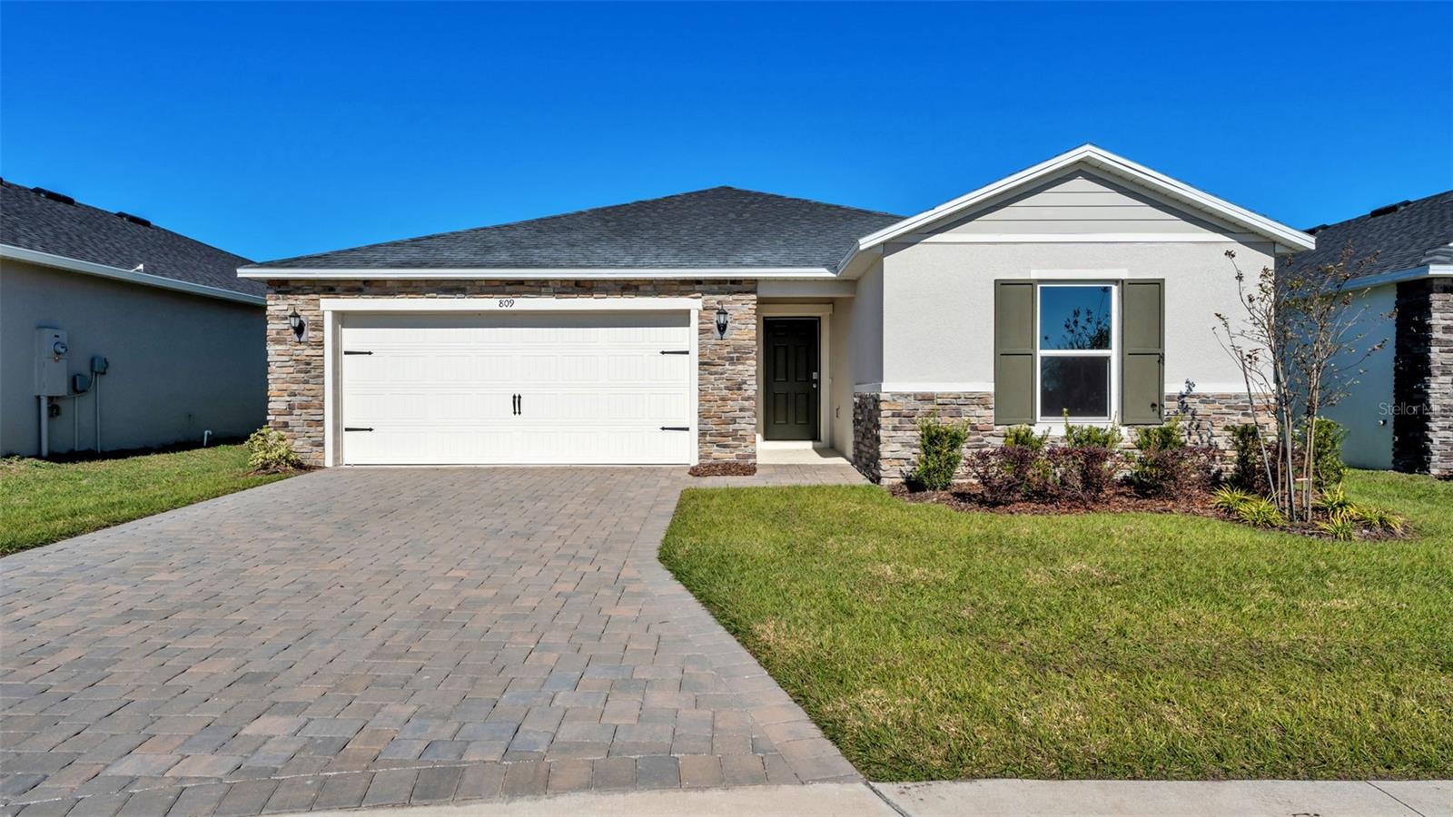 This single story layout features an open floor plan with tile flooring in the main living areas and a spacious great room with volume ceilings. The kitchen includes a large island, granite countertops, stainless steel appliances, and ample cabinet space. The primary suite offers a walk in closet and a private bath with dual sinks and a walk in shower. A covered back patio provides additional outdoor space. The community also includes a pool and dog park for added convenience.