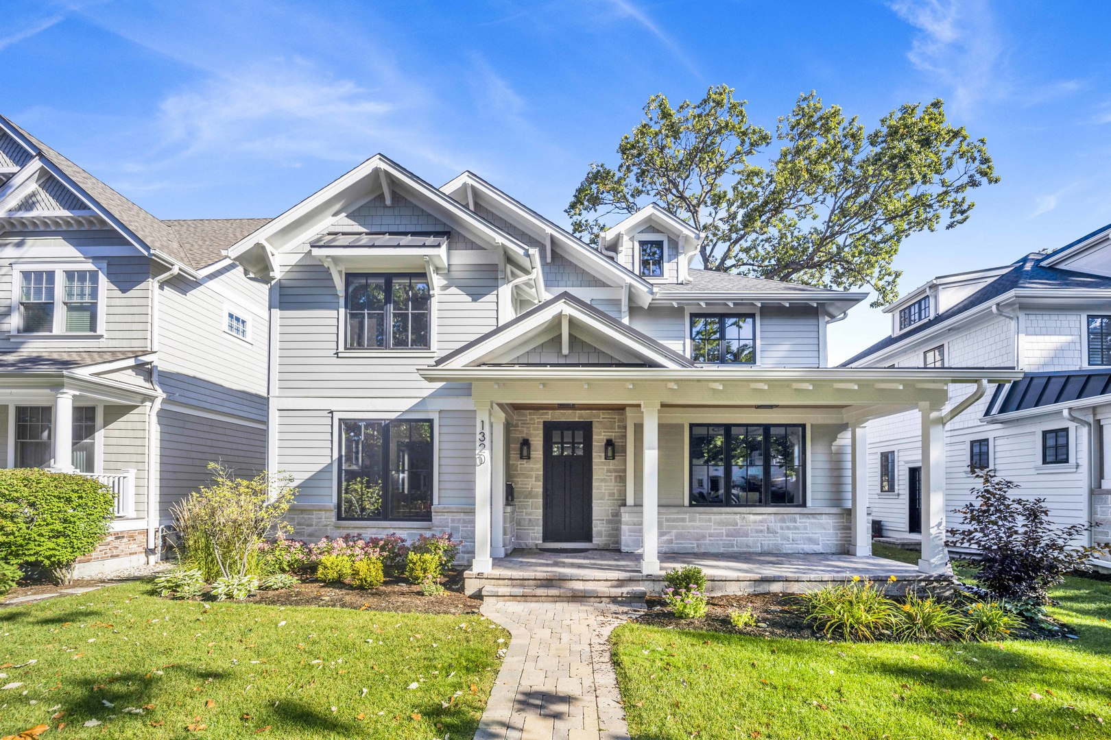 Constructed in late 2022, this nearly new custom home combines timeless craftsmanship with modern amenities, just a 10-minute walk to downtown Wilmette, the Metra, and McKenzie Elementary. Built by a respected North Shore builder, the residence spans over 5,500+ square feet across four finished levels, offering 6 bedrooms and 5.1 baths.  A welcoming front porch opens into a gracious foyer where wide-plank hardwood floors, custom cabinetry, fine moldings, and oversized windows set the tone. Tall ceilings throughout create a bright, airy ambiance. The main level is ideal for entertaining, with seamless flow between the formal living room, wainscoted dining room, and an open-concept kitchen/family room. The chef's kitchen is equipped with Wolf and Sub-Zero appliances, quartzite countertops, a large center island, abundant storage, and a sunny breakfast nook. The adjoining family room features a fireplace and custom entertainment center, opening to a rear patio and landscaped yard. A private office with coffered ceiling, chic powder room, and fully outfitted mudroom complete the first floor. Upstairs, the primary suite offers two walk-in closets and a spa-inspired bath with soaking tub, walk-in shower, and dual vanities. Three additional bedrooms include one en-suite plus a Jack & Jill bath, along with a convenient laundry room. The finished third floor attic provides a versatile bonus space with full bath-perfect as a playroom, office, or guest retreat. The lower level with 9'7" ceilings expands living space with a large recreation room, kitchenette, play/exercise area, wine cellar, private study/bedroom, and full bath. Additional highlights include a 20' x 22' oversized garage, in-ground irrigation, 2-zone HVAC, and a full security system. This move-in-ready home offers the rare combination of nearly new construction and a prime location near downtown, schools, restaurants, and shopping-within the highly sought-after McKenzie Elementary and New Trier High School districts.
