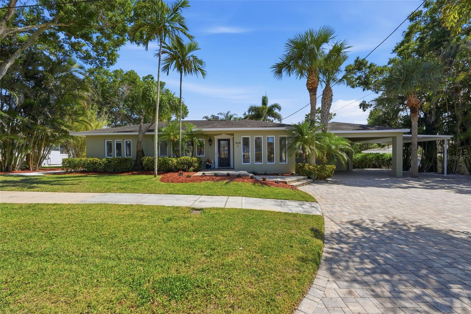 Welcome to this exceptional four-bedroom, three-bathroom home in Tarpon Springs offering 2,973 square feet of beautifully updated living space in a desirable non-flood zone. The property features an ADU out back and main house updates include an A/C installed in September 2025, Patriot air scrubber system for improved indoor air quality, new electric tankless water heater, new breaker panel installed in July 2025, Rinnai gas tankless water heater, and newly installed propane tank and lines in September 2025. From the moment you arrive, the large pavered driveway and three-car carport create impressive curb appeal, while peek-a-boo views of the bayou from the front of the home add to the coastal charm. Inside, the home showcases crown molding throughout, travertine flooring, and brand-new engineered hardwood flooring installed in 2025. Fresh paint and updated finishes complement the spacious layout, which includes an additional flex room, ideal for working from home, a media room, or additional guest space. The heart of the home is the gorgeous open kitchen designed for both entertaining and everyday living. Marble countertops, multiple breakfast bars for casual dining, a center prep island, abundant cabinetry, and a coffee bar with wine fridge create a luxurious and functional space. Premium appliances include a Frigidaire Gallery induction cooktop with fast boil technology and a Bosch fast-heat oven for quick preheating and efficient cooking. The spacious primary suite offers a relaxing private retreat with direct access to the outdoor patio through a set of French doors. The bedroom features a ceiling fan, walk-in closet with organizers, and a conveniently located washer and dryer. The en-suite bathroom includes a double-sink vanity and an oversized glass-enclosed shower with dual shower heads and built-in bench seating. The second bedroom also features its own attached private bathroom, offering excellent flexibility for guests or multi-generational living. Designed for year-round Florida enjoyment, the private pool can also function as a hot tub, creating the ultimate backyard oasis for entertaining or relaxing. Two fireplaces, one in the living room and another in the family room, add warmth and character throughout the home. The additional dwelling unit is equipped with a ductless mini-split A/C, dehumidifier, wine fridge, extensive custom cabinetry, and abundant storage space, providing excellent versatility for guests, hobbies, or a private retreat. Ideally located just minutes from the famous Tarpon Springs Sponge Docks, residents can enjoy local dining, boutique shopping, waterfront attractions, parks, and nearby golf courses. Outdoor enthusiasts will also appreciate close proximity to Fred Howard Park and Sunset Beach for boating, beaches, and spectacular Gulf Coast sunsets. This remarkable home offers an incredible opportunity to enjoy luxury living in one of Tampa Bay’s most charming coastal communities. Schedule your tour today!