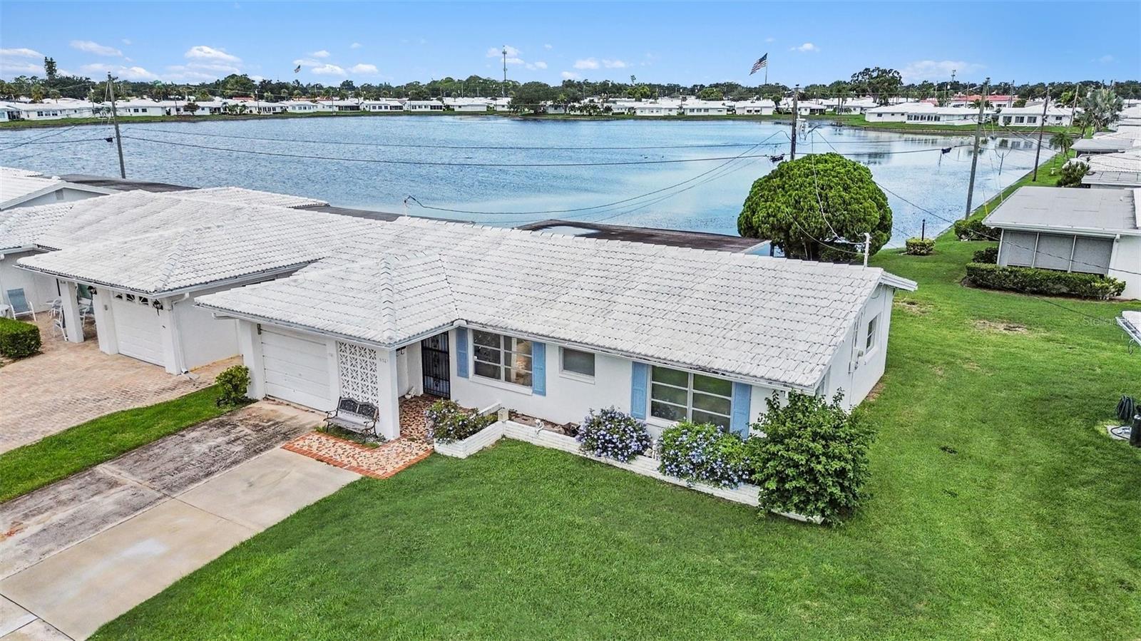 Welcome to this charming waterfront home in the desirable 55+ community of Mainlands of Tamarac by the Gulf! Situated along a beautiful pond, this 1,328-square-foot home offers peaceful water views from the back of the home and an unusually spacious yard that gives you plenty of room to enjoy the Florida sunshine. Inside, you’ll find a clean and well-kept home with much of its original character intact, offering a wonderful opportunity to update and make the space your own. The spacious floor plan includes a bright living area, separate dining space, kitchen with abundant cabinetry, and a large rear living space lined with windows overlooking the water, easily one of the best features of the home!! Both bedrooms offer plenty of natural light, and the attached garage provides additional convenience and storage. Outside, enjoy the open green space and serene pond setting right in your backyard. The association provides extensive maintenance and community amenities, including a clubhouse, swimming pool, shuffleboard courts, cable and internet, lawn care, irrigation, water, sewer, and more. With its beautiful setting, generous yard, waterfront views, and tons of potential, this home is ready for its next owner to bring their vision and make it their own! Please note: The association has been notified of the visible water staining in the rear room and is currently in the process of addressing the roof.