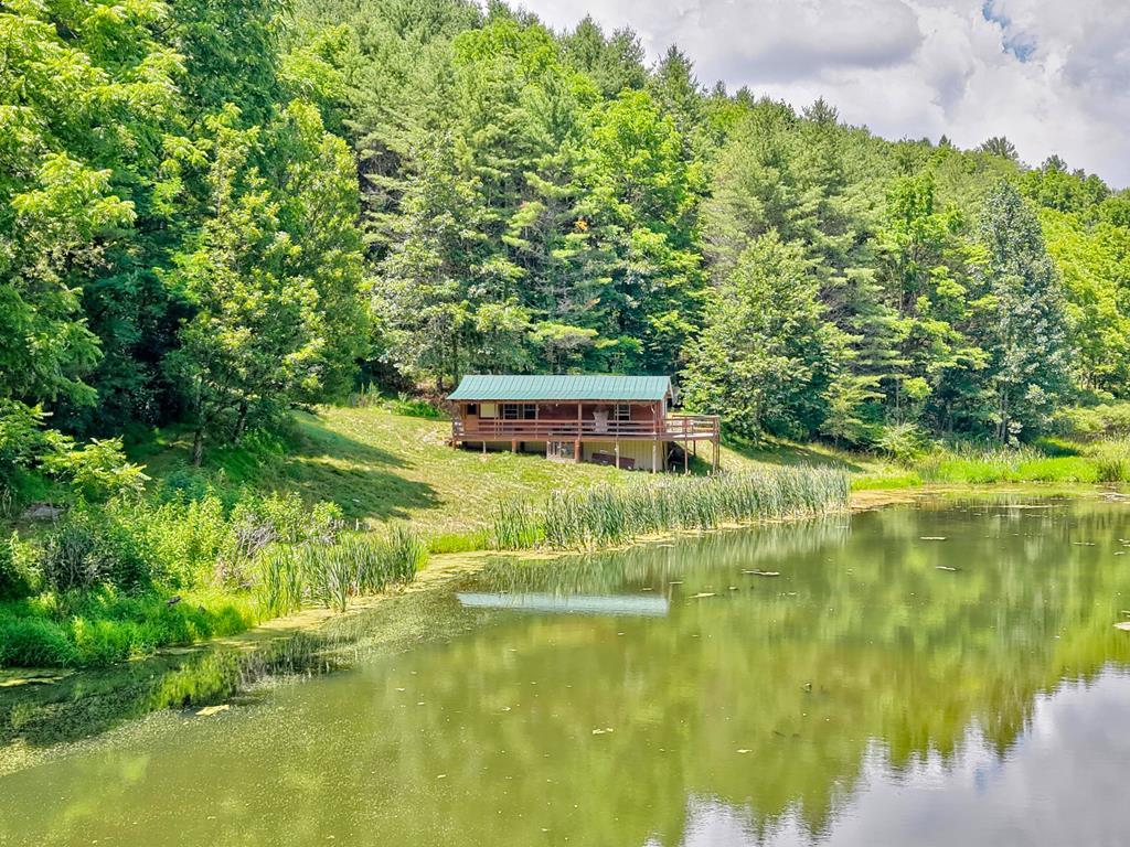 Tucked deep in the woods, this 1-bedroom, 1-bath cabin is the kind of place you dream about when you need to get away from it all. Surrounded by towering hardwoods and pines with complete privacy, this hidden retreat offers peace, quiet, and a true connection to nature. A beautiful spring-fed pond steals the show, providing great water and the perfect spot to fish, paddle a kayak, or relax around the campfire after a day in the woods. Whether you're looking for a hunting camp, weekend getaway, or a simple place to unplug, this cabin delivers an authentic backwoods experience. If solitude, fresh mountain air, and evenings by the water sound like your kind of escape, this secluded hideaway is waiting for you.