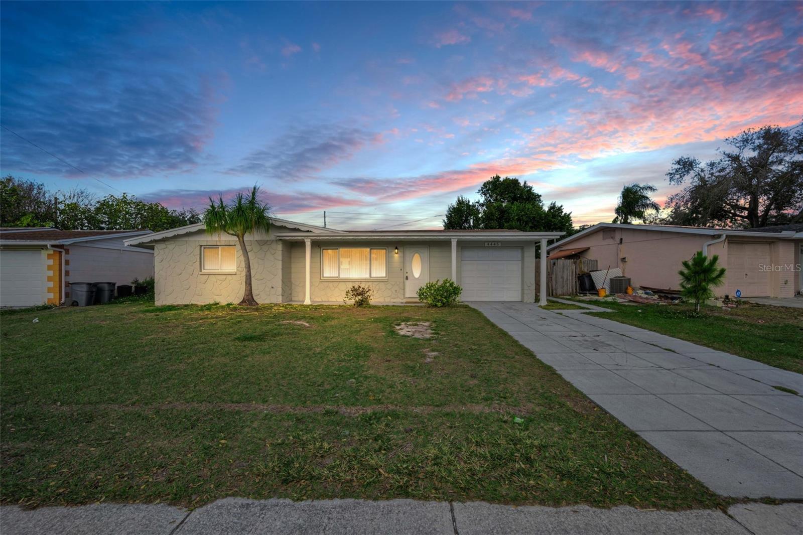 One or more photo(s) has been virtually staged. Welcome to this charming 2-bedroom, 1-bath, 1-car garage home in the heart of New Port Richey, offering inviting curb appeal and a welcoming front porch that sets the tone from the moment you arrive. Inside, the home is light and bright, featuring tile flooring throughout the living and dining rooms and large windows that fill the space with natural light. The kitchen is conveniently located just off the dining area, creating an easy flow for everyday living and entertaining.Both bedrooms are nicely sized, and the updated bathroom adds a fresh, modern touch. A spacious family room at the back of the home provides additional living space, perfect for relaxing, working from home, or hosting guests. Recent updates include fresh interior paint and new carpet, making this home truly move-in ready.Step outside to enjoy the fenced backyard and patio, ideal for outdoor dining, pets, or weekend gatherings. Conveniently located near shopping, restaurants, medical facilities, and everyday amenities, this New Port Richey home offers comfort, functionality, and a great location for Florida living.
