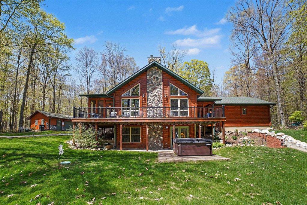 Tucked away on over 11 acres of rolling, wooded land, this one-of-a-kind log home feels like a peaceful retreat from the moment you arrive. Built in 2015 with love, care and creativity. Step inside and youre welcomed by warm wood tones and a stunning stone fireplace that anchors the living space. The handcrafted mantel, along with the kitchen bar and bathroom countertops, were all made from trees that once stood on this very land, giving the home a deep sense of connection to its surroundings. The main floor features a comfortable layout with the primary bedroom and its own private bathroom, along with a second bedroom and bathroom for guests or family. Downstairs, the walk-out basement offers a third bedroom, an additional living area, and another full bathroom-perfect for hosting or creating a cozy retreat space. Step right outside from the basement to enjoy the hot tub, a perfect spot to relax under the stars. Enjoy quiet mornings on the screened porch, take in the views from the large deck, or unwind on the covered porch as you listen to the sounds of nature all around you. The property itself is a mix of wooded beauty and gentle rolling land, offering privacy, peaceful surroundings, and room to explore. In addition to the main garage, theres also a secondary garage that has a woodstove-ideal for extra storage, hobbies, or all your outdoor gear. This isnt just a home-its a place where craftsmanship, nature, and comfort come together to create something truly special.