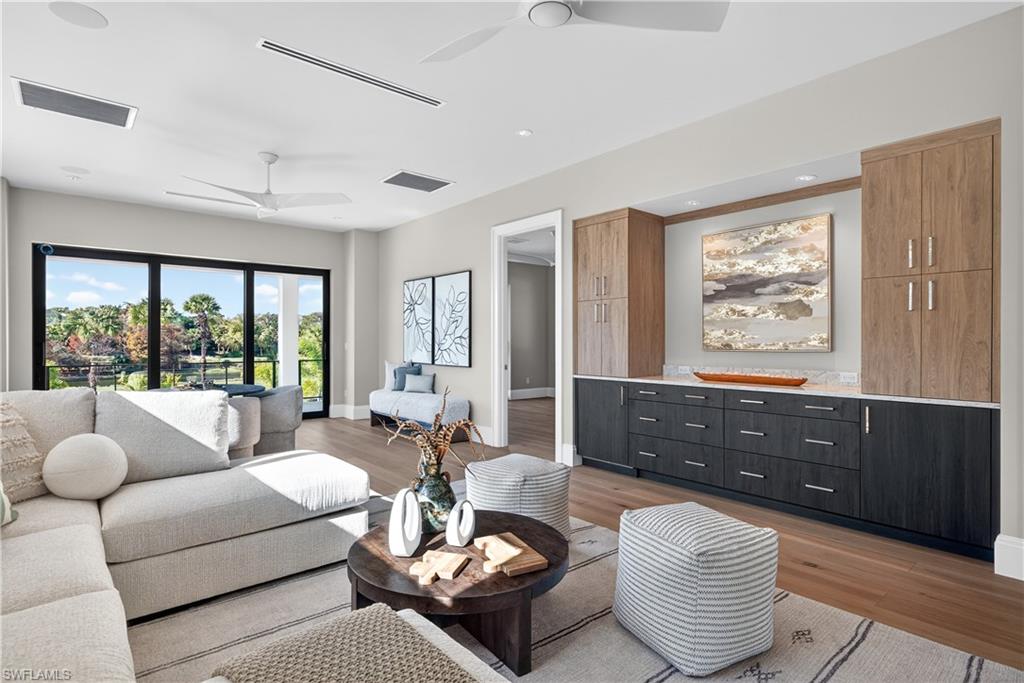 Living area featuring light wood-style flooring, a ceiling fan, and recessed lighting