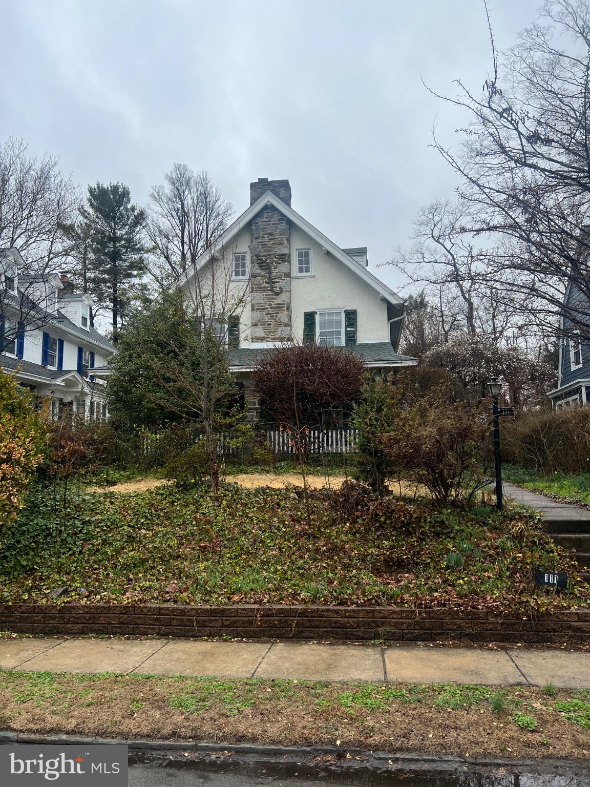Rare Main Line opportunity in the heart of Bala Cynwyd! This impressive 3-story, 6BR/2.5BA stone & stucco home sits elevated on a mature lot with undeniable curb appeal. Classic Pennsylvania fieldstone exterior, covered porch with arched millwork & ivy-draped columns, and a grand multi-flight staircase with original hardwood treads, elegantly turned white spindle balusters, and distinctive pyramid-capped newel posts set the tone for the architectural character found throughout. Spacious living room with wood-burning fireplace, formal dining room with original hardwood floors & chandelier, and an oversized kitchen with room to create the open-concept layout today's buyers desire. Six bedrooms across multiple floors offer flexibility for any lifestyle. Original clawfoot tub, dormered third-floor rooms with character-filled vaulted ceilings, and a side yard with mature plantings round out this remarkable property. Sold strictly as-is — property is in need of major renovation — but the bones, the block, and the address are second to none. Lower Merion SD. Minutes to Center City, the Cynwyd Heritage Trail, and all the Main Line has to offer. Bring your vision and your contractor — this is the one you've been waiting for!