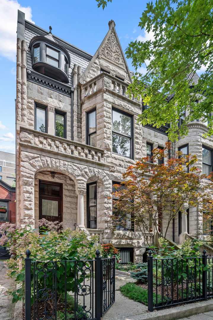 2831 N. Pine Grove Avenue  This is a rare opportunity to own an exceptionally impressive Chicago Greystone, situated on a deep 198-foot lot just moments from Lincoln Park and the lakefront. A masterclass in historic preservation meeting modern luxury, this residence offers a beautifully landscaped backyard that serves as a private bridge between the main house and a phenomenal coach house, complete with a three-car garage.  The main residence features five bedrooms and three-and-a-half baths across three expansive levels. From the moment you step through the front entrance, the home's timeless elegance is on full display. You're greeted by soaring ceilings, a grand staircase, and a large living room that flows effortlessly into the formal dining room. The renovated chef's kitchen is a true centerpiece, featuring commercial-grade appliances and high-end finishes that make hosting a joy. Throughout the home, meticulously preserved vintage details-intricate moldings and classic millwork-pair perfectly with contemporary amenities.  The second floor offers four gracious rooms, currently configured as two spacious bedrooms, a custom wood-paneled office, and a library drenched in natural light. The entire top floor is dedicated to a serene primary suite, featuring a large walk-in closet and a spa-inspired bath designed for relaxation.  Adding incredible versatility to the property is the fully equipped coach house. The lower level offers a flexible "swing space" ideal for a workout room, second office, or hobby studio, along with an additional laundry room. Upstairs, the coach house reveals a grand living area, a well-appointed kitchen, a full bath, and a large bedroom-perfect for guests or a quiet personal retreat.
