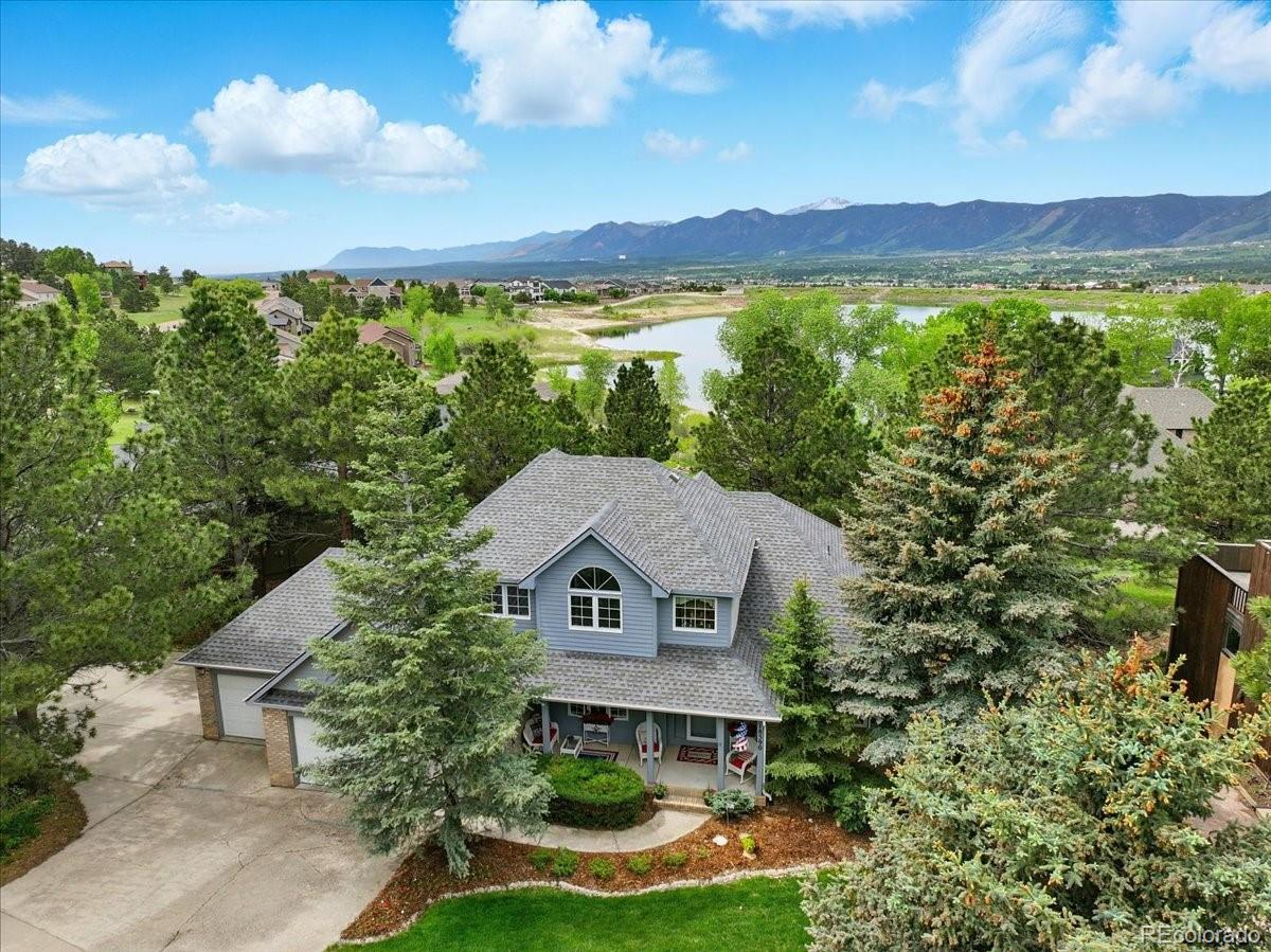 Waterfront living on Woodmoor Lake - this beautiful traditional-style two-story home sits right on the edge of the beautiful lake for a RARE opportunity to enjoy the mountains and the water at the same time! This picture-perfect home sits on a tree-lined street with a story-book perfect covered front porch and open wrap-around deck to take in the lake views. Unobstructed access to the lakefront from the backyard and lower level with TWO walkouts! 
The main level features a formal entry that is open to the formal dining room and living room and new engineered wood flooring throughout. The living room has double glass doors that open to the deck and the lake views, plus a fireplace and ceilings that are open to the second story. The remodeled kitchen has a back wall of windows overlooking the lake with walk-out access to the deck. Off the kitchen is a half bath and a walk-in pantry that has hidden plumbing in case you would like to add a second laundry later. 
The primary bedroom also has double-glass-door walk-out access to the deck along with lake views and an ensuite bath. The upstairs has a full bath and three bedrooms, plus an interior balcony overlooking the entry. The lower level really shines with a custom bar, open family room, separate office/library/study, another bedroom, a 3/4 bath with steam shower and a huge laundry room with another office area and tons of storage space.
Off the basement walk-outs is a lower patio w/lake views, and stairs up to the deck. 
Even the garage in this home is perfection - it's finished with epoxy floors and TONS of storage. The sellers have taken amazing care of this home and it shows. 
The street ends in a cul-de-sac so there's no through traffic and you're close to the Monument Library, popular hiking and biking trails, major traffic corridors for easy commutes to Colorado Springs or Denver, and so much more. This home is located in the D-38 Lewis Palmer School District and is close to schools, shopping and more.