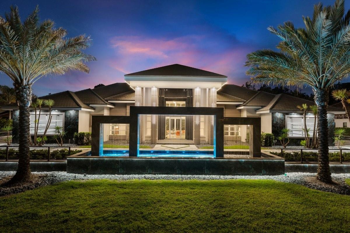 Welcome to a world of modern, stylistically innovative elegance in this 5-bedroom, 7-bathroom, dual-garage, custom-built architectural masterpiece on a double preserve lot in the coveted Woodbridge Estates neighborhood of Plantation Bay. This home projects an aura of contemporary grandeur, with private gated entrances to the circular driveway that flank either side of a 40’ rainfall entryway fountain & lead to two-vehicle garages on both the north & south sides of the home.The formal entry features a custom 10’ glass pivot door that opens into a foyer with soaring 25’ ceilings w/ views through to the backyard’s private saltwater pool & forested preserve beyond. No expense was spared in outfitting this home’s functional surfaces, including porcelain tile floors throughout, corner shelving with inlaid LED accent lighting, multi-trayed ceilings, floating vertical tiled walls with backlit accents, solid wood interior doors & trim, & a hallway of fluted wood panels with inlaid LED lights.The living room’s sliding glass doors flood the open floor plan with sunlight. To the south side of the grand living area is the formal dining space which is home to a built-in linear gas fireplace. Just beyond, yet connected via engawa-styled transitional colonnades, is the chef’s formal kitchen featuring imported European-style cabinetry, Cambria waterfall edge countertops, a Wolf gas range with infrared center griddle, double ovens, pot filler, range hood & a wall of Sub-Zero appliances including a column refrigerator, freezer & wine cooler, along with a built-in coffee machine, microwave & warming drawer. The center island is home to a Ruvati trough-style sink with double Moen faucets, Asko dishwasher & a custom inlaid Cambria accent wall.Don’t like a mess? No worries—the scullery kitchen hides everything! This fully functional secondary kitchen features all GE Monogram appliances. The south wing is also home to 3 bedrooms with en-suite bathrooms, each with walk-in closets outfitted with built-in organizers, a half bath with access to the backyard, a laundry room with double stacked Samsung washers & dryers, utility sink, storage cabinets, & mudroom entry from the south garage.The north wing of the residence is home to a 4th bedroom with an en-suite bathroom & walk-in closet, a home office/study, entrance to the north garage & a magnificent powder room reminiscent of a jewel box. This wing is home to the grand primary suite—a sanctuary of privacy & seclusion.The en-suite primary bathroom features painted enamel cabinetry, a matte red freestanding soaking tub, his-and-hers vanities with backlit floating mirrors, & a walk-in shower that runs the entire length of the back wall. Doors open out to a 21.8 x 17.4 spa garden with privacy walls of porcelain tile, lush planters, and travertine floors. Back inside, find a makeup vanity, a commode closet containing an Ove Smart Toilet & a boutique style walk-in closet with a custom-designed center storage island.Outdoors, the home transforms into a private resort with covered lanai, outdoor living room, as well as an outdoor kitchen featuring a Tru-Flame propane grill with LED lighting & SS Sub-Zero beverage fridge. After a refreshing swim in the 20’ x 60’ saltwater pool, the sunken gas fire pit is the perfect spot to sit while enjoying the sights and sounds of nature. This home is more than just a residence—it is a statement of lifestyle, crafted for those who expect nothing less than exceptional.