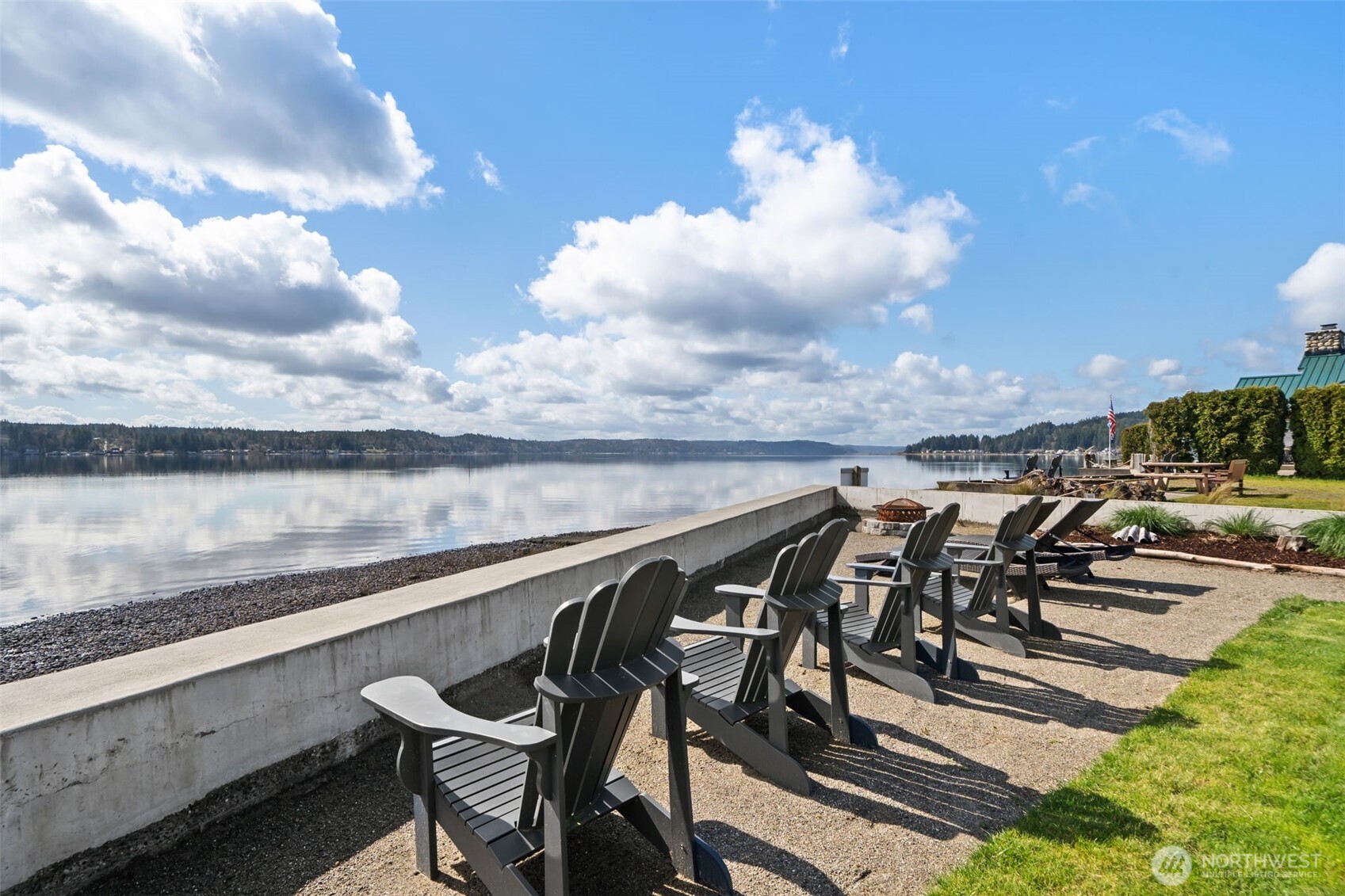 There is a moment—just as you leave the city behind—when everything begins to slow. This is where it leads. A beautifully remodeled Hood Canal retreat with 50' of no-bank bulkhead frontage and owned tidelands, where weekends stretch longer and time feels different. Just an easy drive from Seattle or Bellevue, it is the kind of place you arrive Friday afternoon and instantly exhale. Wake to soft eastern light over the water. Step outside with coffee in hand, the canal just feet away. Spend your day paddleboarding, kayaking, or beachcombing, harvesting oysters and clams from your own shoreline. As evening falls, gather on the covered deck, light the firepit, and take in the stillness of the canal. Inside, vaulted ceilings and expansive windows invite light and calm. Whitewashed cedar walls and ceilings pair with warm LVP flooring for a relaxed coastal aesthetic. The remodeled kitchen is designed for effortless entertaining, while the primary bedroom offers flexibility with barn doors. A guest bedroom and updated 3/4 bath complete the home. Detached garage, ample parking, fenced yard, and option to purchase furnished create an easy lock-and-leave retreat—close to the city, yet a world away. It is the luxury of simplicity: a place to gather close friends, host effortless summer weekends, and give busy lives a beautiful reset. Rarely does a waterfront property feel this approachable, this polished, and this easy to enjoy from the moment you arrive. In every season, it delivers.