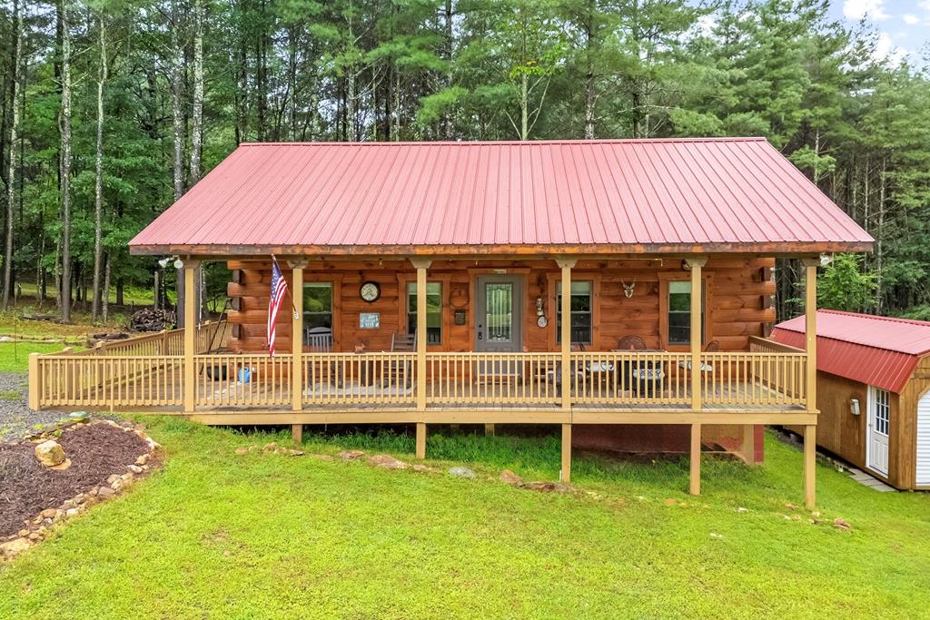 Welcome to Your Log Cabin Retreat in the Blue Ridge Mountains  Tucked away in a beautiful cabin community in Fancy Gap, this 2018 custom-built log home is the kind of place that just feels right the moment you arrive. It offers 756 sq. ft. of comfortable one-level living with 2 bedrooms, 2 full baths, an open living room and kitchen, a laundry area, and beautiful hardwood floors throughout. The authentic log construction, metal roof, and efficient heat pump make this home both charming and practical — easy to maintain and ready for every season. Step outside and you'll love the 340 sq. ft. covered front porch, perfect for morning coffee or quiet evenings watching deer wander by. The 636 sq. ft. of open decks along the side and back offer plenty of space for family, friends, and fresh mountain air. A 12  24 detached building/garage gives you extra room for a workshop, storage, or hobbies. The newly added drainage ditch, lined with decorative gravel and a small bridge, adds both character and function to the property. All furniture and most household items convey, so you can move right in and start enjoying mountain life from day one. And here's the best part — you still have time to spend Thanksgiving here this year, surrounded by the beauty and peace of the Blue Ridge. For your peace of mind, the seller has already paid for a professional home inspection, giving you added assurance that this is a well-built, fully functioning home ready for you to enjoy. Located just 5 miles from I-77, Highway 52, and the Blue Ridge Parkway, this cabin gives you the best of both worlds — peaceful privacy with easy access to town. Whether you're looking for a full-time home, a weekend getaway, or a turnkey vacation retreat, this one has it all: rustic beauty, modern comfort, and that quiet, peaceful feeling that only the Blue Ridge can give. (Speak to list agent for items that convey)