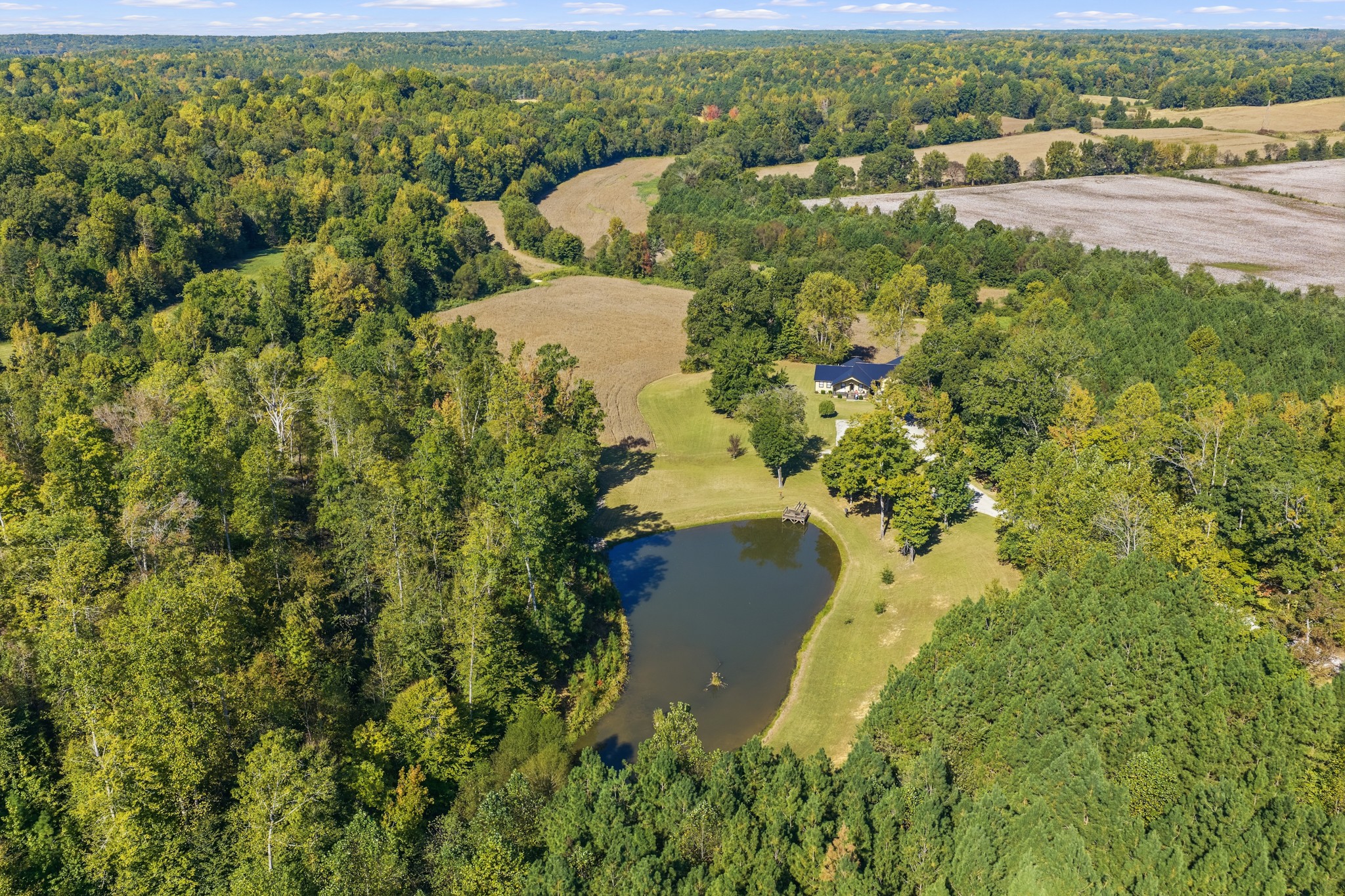 315.26 ACRES!!! CUSTOM LOG HOME, 9 PONDS, CREEK & SPRINGS! An exceptional blend of privacy, natural beauty, & versatility on this diverse 315.26-acre property! Featuring 9 ponds (5 on the home side, 4 on the barn side), natural springs, & Birdsong Creek running across the property, the acreage provides abundant water for wildlife, hunting, & recreation. Enjoy trails, hardwoods, row-crop land, hay fields, & acreage previously used for cattle farming. Westport Rd frontage at both the north & south ends, w/the property stretching over a mile north to south! A private gravel drive leads approximately .2 miles from the south entrance to the custom log home, built using trees harvested from the property! Enjoy scenic pond & countryside views from the vaulted wood-ceiling front porch & private deck. Inside, vaulted wood ceilings & beautiful tongue-and-groove walls complement the well-appointed kitchen, breakfast bar & large dining/gathering room The massive living room features a gas fireplace, generous storage, & access to the open deck. Primary suite w/2 walk-in closets, a walk-in shower, & double vanities. 2 additional BRs provide flexibility, including one ideal for an office. Outdoor living spaces include a covered patio betw the home & garage, open grilling patio, & expansive covered front porch. Oversized attached garage accommodates boats, side-by-sides, & recreational equipment. An adjoining heated/cooled workshop with lean-to is perfect for woodworking & hobbies. Recent updates include a NEW metal roof, HVAC, kitchen countertops, carpet, & exterior doors.At the north end, an older block barn with lean-tos, separate gravel entrance, & installed (but not hooked up) water meter offers additional agricultural, storage, or workshop potential. Ideal for a generational farm, hunting retreat, multiple homesites, or investment. Only 9 m to I-40-1.5 hr to Nashville.Own a remarkable piece of Tennessee countryside w/privacy, water, & acreage rarely found in one property!!!