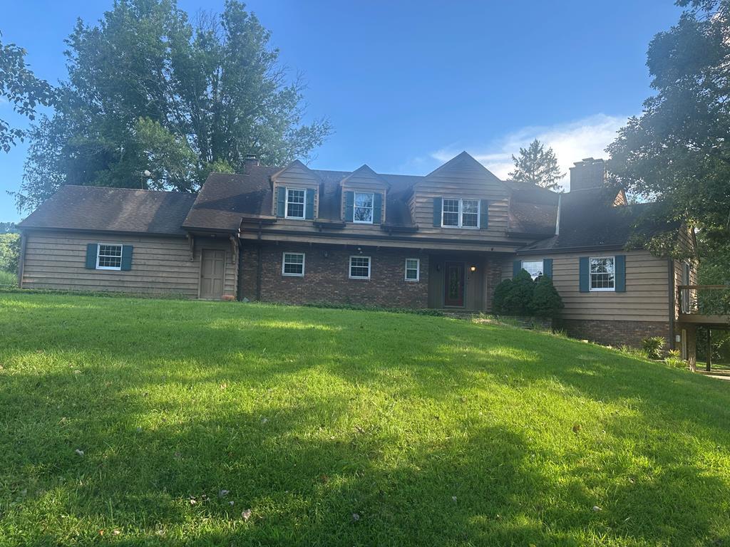 This beautifully crafted Cape Cod-style home offers an exceptional living experience with its grand architectural design and attention to detail. With 5 bedrooms, 4 1/2 baths, and located on a generous 2.26-acre lot at the end of a peaceful cul-de-sac, this home provides both privacy and elegance.  Upon entering, you are greeted by slate flooring and a stunning staircase that leads to the upper level. To the right, the formal living room stands out with a marble fireplace, plaster walls, and wood wainscoting adorned with walnut molding. The 12-inch oak plank tongue-and-groove solid wood flooring with walnut plugs adds a touch of luxury and warmth to the space.  The dining room mirror's the beautiful 12" oak wood flooring with wood along with hand carved chair rail and patio doors that lead outside to the brick patio. The primary bedroom suite, with an adjoining den featuring a cozy brick fireplace and wet bar, offers a true retreat. Just off the primary bedroom is the spacious full primary bath, complete with a soaker tub, step-in shower, and double vanity, providing both comfort and functionality. For convenience, there is a 1/2 guest bath with an adjacent storage closet on the main level.  A large laundry area off the garage with plenty of cabinetry, a laundry chute, built in ironing board and a second staircase leading to the upper level. The upper floor features four  spacious bedrooms, each with ceiling fans, two full baths, and a large storage room.  This home offers 4,077 square feet of finished living space, with an additional 800+ square feet on the basement level. The basement includes a home office, a large den/family room with a local fieldstone fireplace, and a walkout that leads to a brick patio.  There is ample sq. footage in the basement to allow for expansion of living space if needed.  Hot water heaters as well as the central vacuum are located on this level.