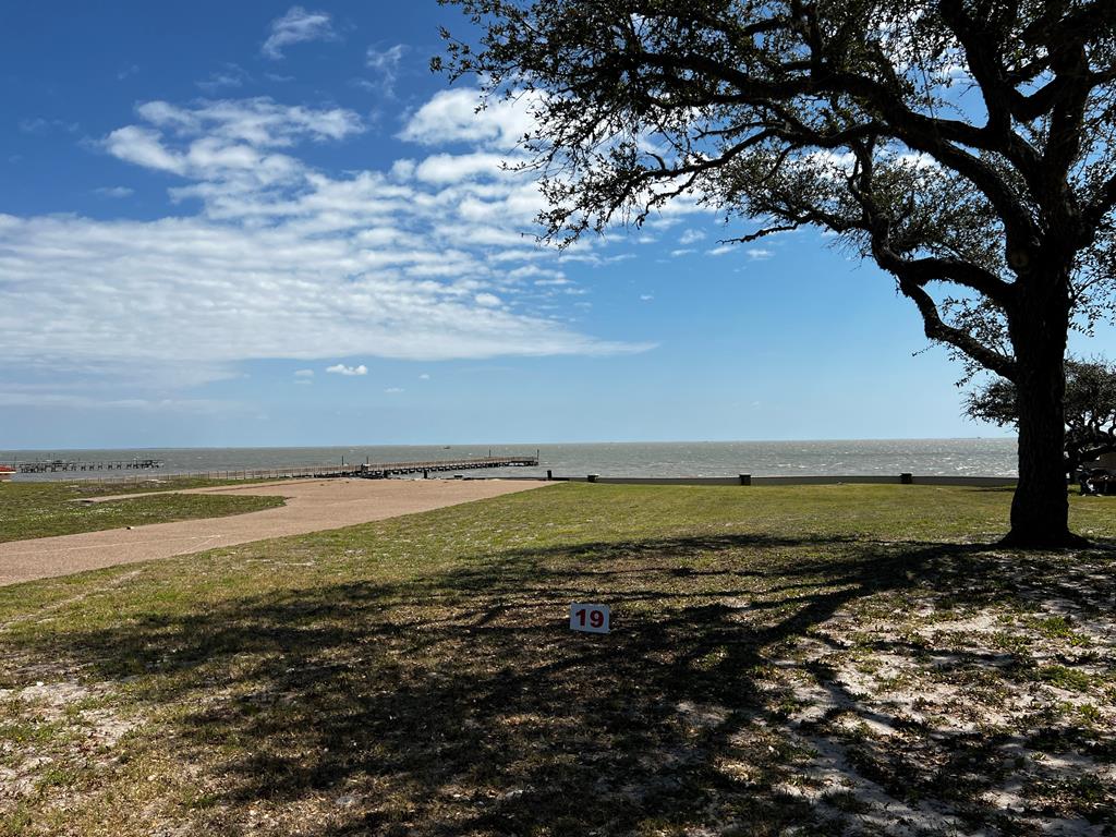 It's time to own your own exclusive inner sanctum in Royal Oaks! Build your custom exceptional waterfront estate on this oversized lot with 180 degree view of Aransas Bay. Wake to the endless sunrises glistening over the Aransas Bay and sweet sounds of the water from this 16559 sq.ft. lot. Royal Oaks is a world unto itself umbrellaed with enchanted windswept Oak trees, sprinkled with sitting areas, walking trails lit with quaint light posts. The tastefully designed neighborhood is gated with easy access to highway 35 and its main entrance fronting Fulton Beach Rd. The cobble stone entrance with guard house meets with the storybook curved stucco and stone privacy fence lining the front and back of the development providing next level privacy. Molded for prestigious living, you will adore the amenities including the two putting greens, stone gazebo with brick fire pit and lighted pier with fish cleaning station.