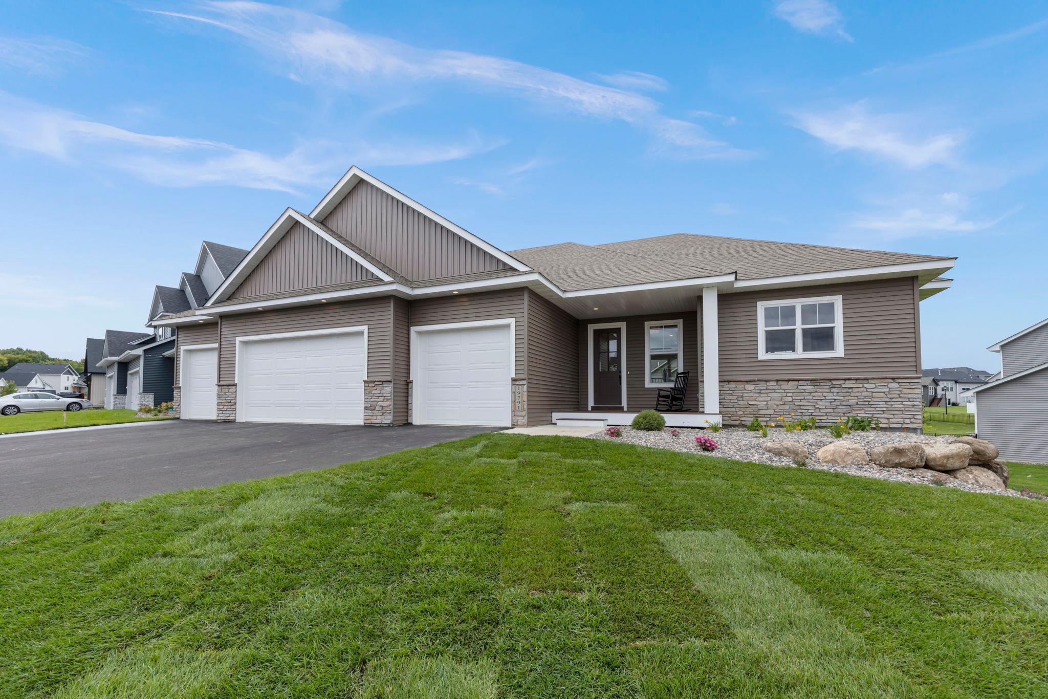 Welcome to the Magnolia III, an exquisite custom-built rambler by Stone Cottage Construction in the Berres Ridge community of Lakeville. This thoughtfully designed home offers 5 bedrooms, 3 baths, and a finished walkout basement, combining luxury and functionality. The open-concept main floor features 10-ft ceilings, engineered hardwood floors, and a stunning kitchen with a large center island, soft-close cabinetry, quartz countertops, gas range with hood vent, and wall oven. The adjacent dining area flows into a spacious great room with an electric fireplace — perfect for entertaining. The main-floor primary suite is a private retreat with a spa-like ensuite bath, dual quartz vanity, tiled walk-in shower, private toilet room, and direct access to a walk-in closet and laundry room. A second main-level bedroom offers flexibility as a guest room or home office, serviced by a full bath. The finished lower level includes a large family room, 3 additional bedrooms, a full bath, and access to the backyard. Enjoy outdoor living on the front porch with TimberTech maintenance free decking, beautiful landscaping with irrigation, and a spacious 4-car garage. A truly exceptional home with high-end finishes throughout! Stone Cottage is a custom builder with various options. Model Hours: Fridays 3-6pm, Saturday & Sunday 11-4pm.