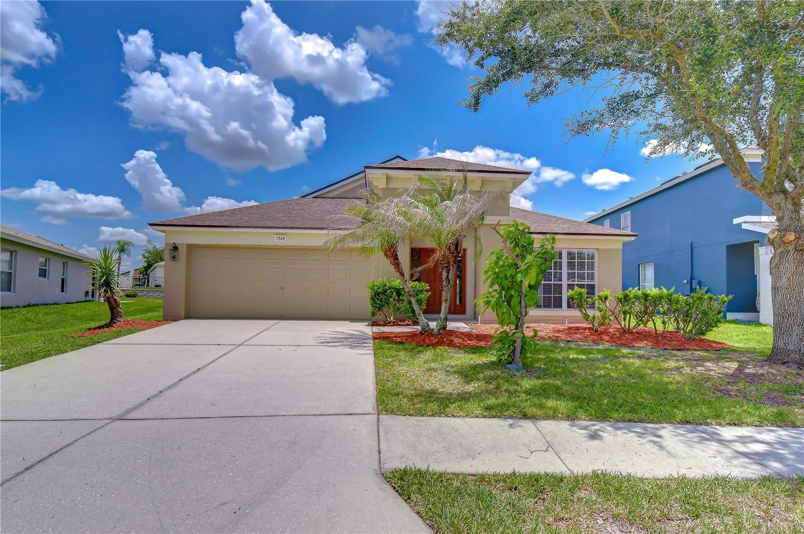 Virtually Staged. WELCOME HOME to this METICULOUSLY MAINTAINED 4-bedroom, 2-bathroom home on an OVERSIZED LOT in the sought-after Palm Cove community of Wesley Chapel! The BRAND NEW ROOF, FRESH EXTERIOR PAINT, manicured landscaping, and striking mahogany front door with sidelights and transom arch deliver OUTSTANDING CURB APPEAL from the moment you arrive. Step inside to a BRIGHT, OPEN floor plan with FRESH INTERIOR PAINT, VAULTED CEILINGS, GLEAMING STEAM-CLEANED TILE throughout all living areas, and BRAND NEW CARPET in every bedroom. The living and dining room flows into the kitchen through elegant arched doorways with decorative columns, featuring white cabinets, a built-in desk nook, recessed lighting, and a BRAND NEW stainless steel RANGE, DISHWASHER, and MICROWAVE. The PRIMARY SUITE offers vaulted ceilings, a SPACIOUS WALK-IN CLOSET, and an en-suite bath with SPLIT DUAL VANITIES, a GARDEN SOAKING TUB, and a SEPARATE WALK-IN GLASS SHOWER. Three additional carpeted bedrooms with closets and a full second bath complete the layout, along with an indoor laundry room and 2-car garage. Outside, the EXTENDED SCREENED-IN REAR LANAI features a covered section with ceiling fans and an open-air screened area perfect for entertaining, all overlooking a MASSIVE BACKYARD with PLENTY OF ROOM beyond the lanai for a playset, garden, or future pool. The SELLER'S PRIDE OF OWNERSHIP shows in every detail: ALL UPDATES COMPLETED JUNE 2026 including NEW ROOF, NEW EXTERIOR PAINT, NEW INTERIOR PAINT, NEW CARPET, NEW RANGE, NEW DISHWASHER, NEW MICROWAVE, and PROFESSIONALLY STEAM-CLEANED TILE. Step DIRECTLY ACROSS THE STREET to the community PLAYGROUND and fenced DOG PARK, and enjoy the RESORT-STYLE COMMUNITY POOL. Palm Cove offers a LOW HOA and NO CDD FEE. Minutes from Publix, Walmart, and Sprouts, with quick access to I-75, SR-54, and SR-56, and close to AdventHealth Wesley Chapel, HCA Florida Bayonet Point, and the future Johns Hopkins All Children's Hospital currently under construction in Wesley Chapel. Top it all off with a short drive to the ONE-OF-A-KIND EPPERSON CRYSTAL LAGOON.