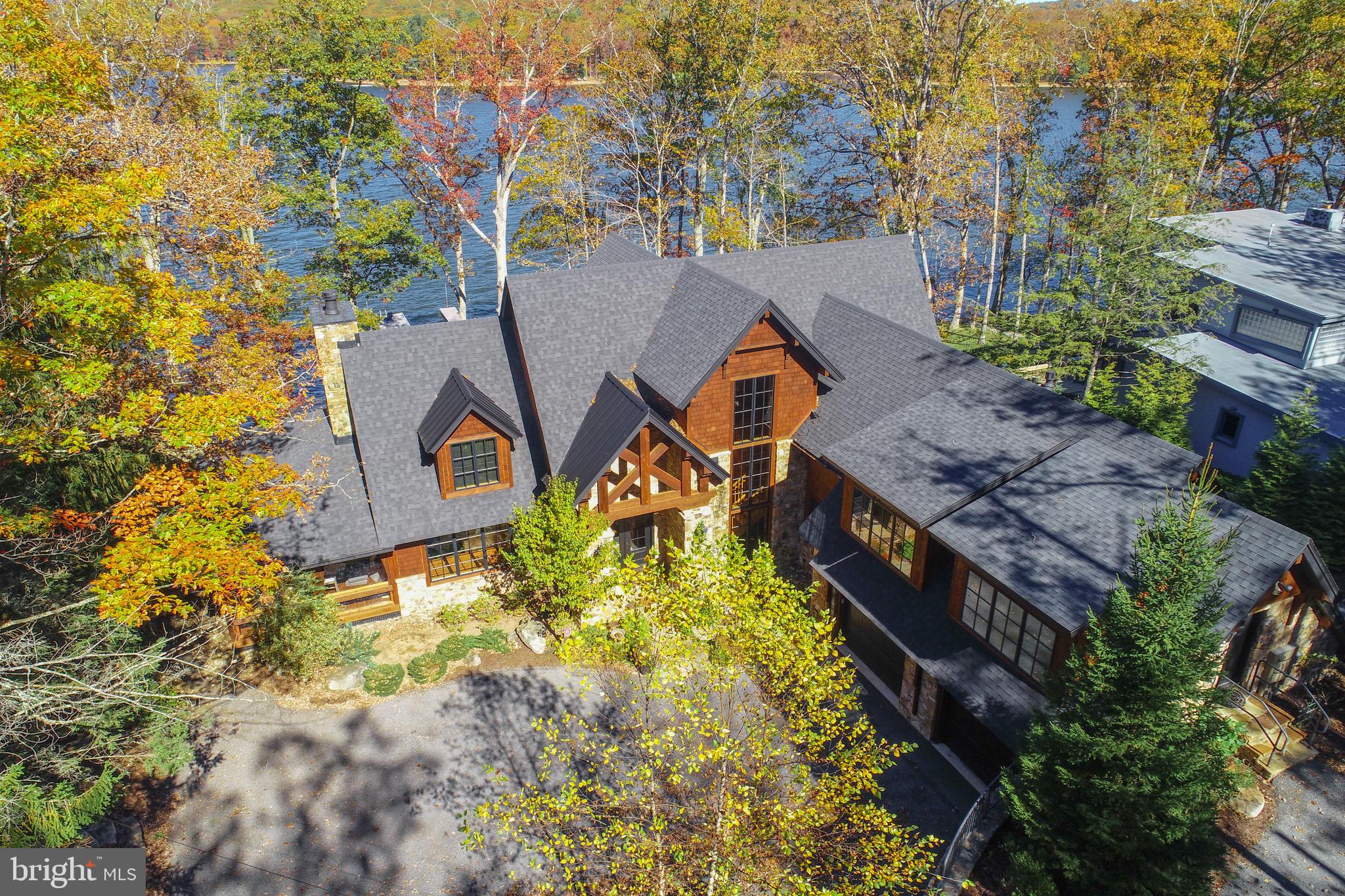 This stunning lakefront residence is a true masterpiece on the shores of Deep Creek Lake — where design, nature, and craftsmanship converge. Completely reimagined and luxuriously curated with Restoration Hardware furnishings, fixtures, and décor throughout, it offers a seamless blend of modern sophistication and timeless mountain warmth.With unobstructed, year-round views of Deep Creek Lake and the surrounding mountains, the scenery is nothing short of breathtaking. The home’s expansive wall of glass brings the lake to your doorstep, with nearly every room offering a front-row view of the water’s edge.The open main-level layout provides effortless living, featuring a gourmet kitchen, four stunning stone fireplaces, vaulted ceilings, and an enclosed screened porch perfect for year-round enjoyment. Each bedroom offers the privacy of an en suite bath, and every detail reflects a commitment to quality and style.From its storybook architecture to its elevated finishes, this home is more than a lake retreat — it’s a statement of elegance and connection to nature. Quite simply, one of the most exceptional properties ever offered at Deep Creek Lake.